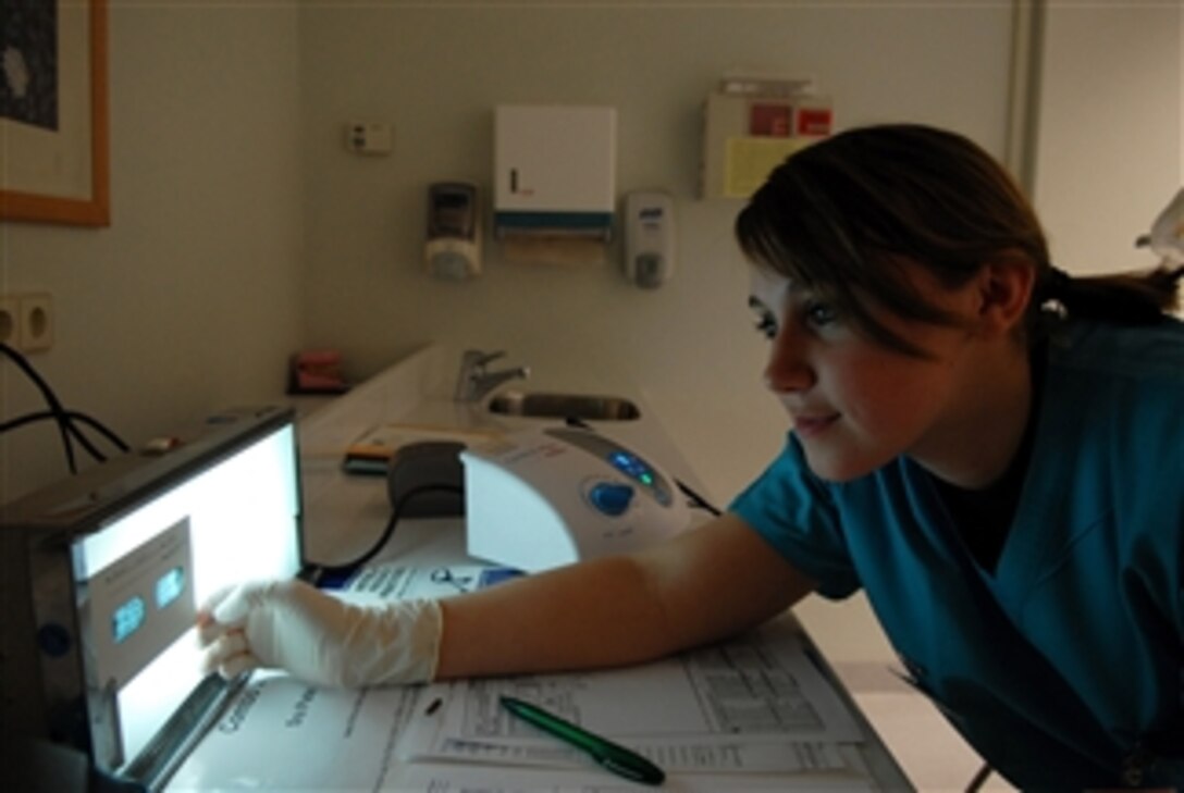U.S. Air Force Airman 1st Class Alaina Clark, a dental assistant with the 435th Dental Squadron, looks at an x-ray in preparation for her next patient at Ramstein Air Base, Germany, on March 26, 2008.  On average, dental assistants care for up to eight patients a day.  