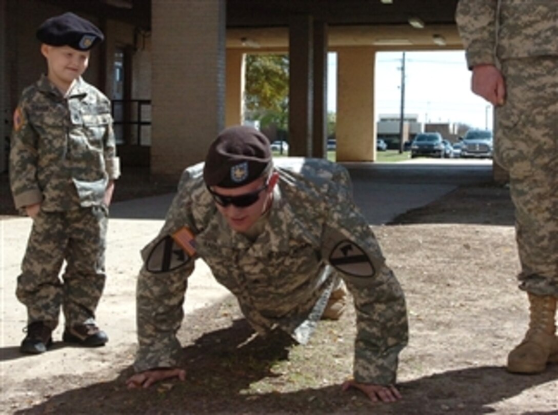 Five-year-old U.S. Army Staff Sgt. Gaven Cox gives Sgt. David Raines the order to do push-ups during a formation on Fort Hood, Texas, March 20, 2008. Through the Make-A-Wish foundation, Cox was given the opportunity to join the 1st Cavalry Division.