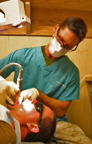 Navy Lt. Gregory C. Hohl, dental officer, CLB-24, 24th MEU, performs oral surgery on a British soldier at Kandahar Airfield, Afghanistan.  Providing dental healthcare is another function of a CLB while deployed.