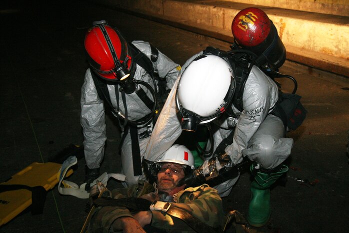 Sgt. Cameron Stewart (left), decontamination platoon team leader, Cpl. Dallas Ward (right) and Lance Cpl. Donnie Hoffman (middle), decontamination platoon team members, all with the Chemical Biological Incident Response Force, II Marine Expeditionary Force, begin to decontaminate a simulated casualty during training here March 29. The Marines and sailors responded to a simulated terrorist attack when a chemical was released in a highway tunnel, initiating several car wrecks. Service members extracted and decontaminated casualties and provided medical care.
