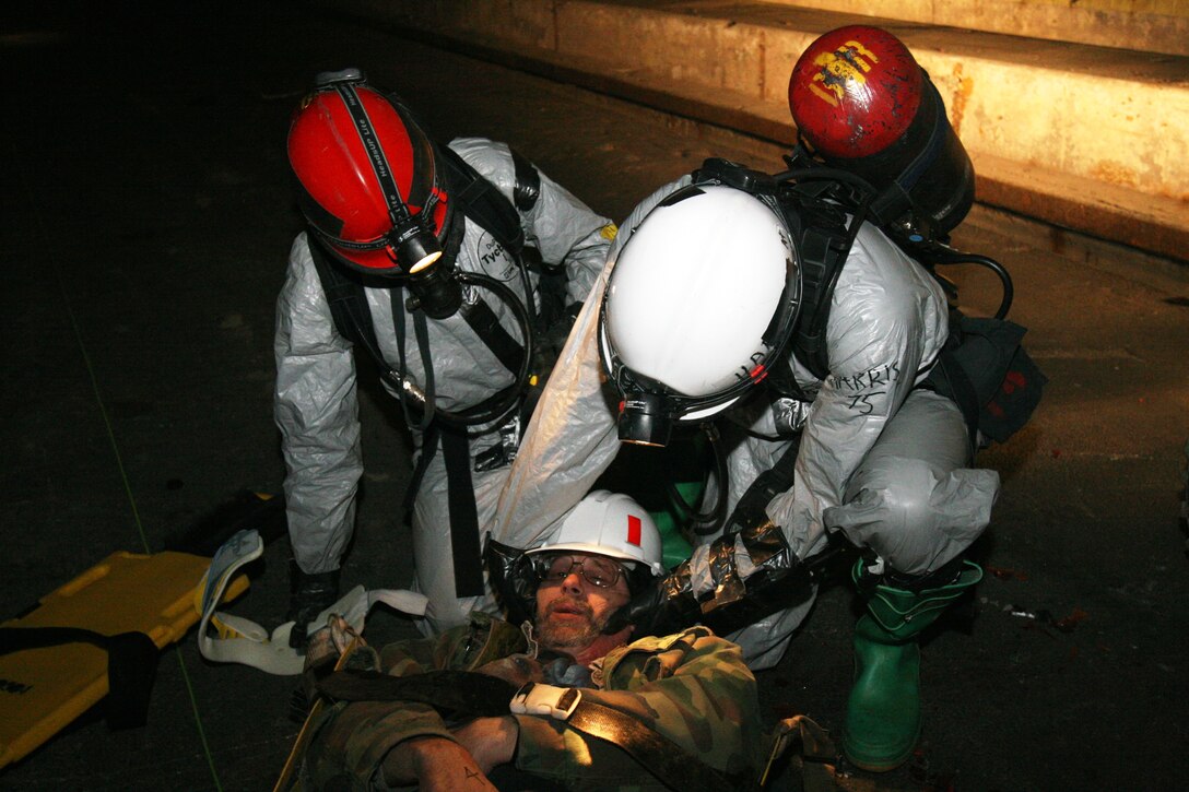 Cpl. Joshua Harris (right) and Cpl. Travis Johnson (left), extractors for Company B, Chemical Biological Incident Response Force, II Marine Expeditionary Force, put a neck brace on a simulated casualty involved in a car wreck, caused by a terrorist attack here March 29. The simulated chemical attack sparked several car wrecks, and Marines and sailors were tasked to extract and decontaminate casualties and provide medical care when necessary.