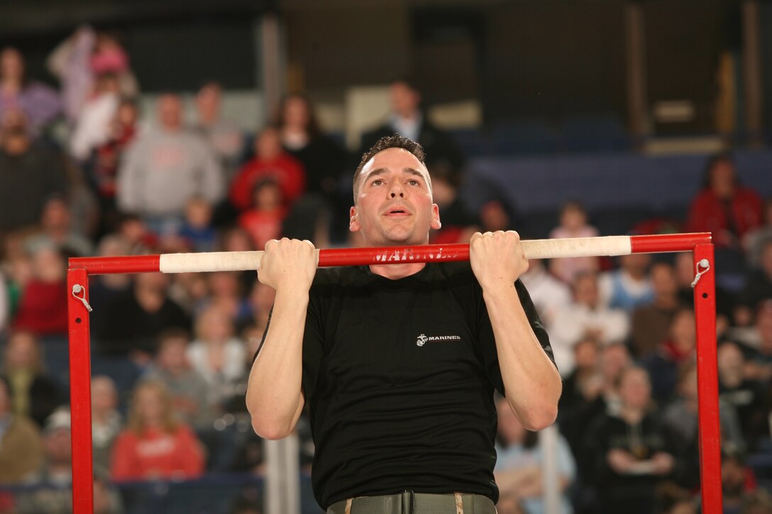 Sgt. Joshua Ritch feels the pressure of performing Marine Corps dead-hang pull-ups in front of 9,636 fans during the Chicago Wolves Armed Forces Night at the All-State Arena in Rosemont, Ill. Ritch, a 24-year-old canvassing recruiter with Marine Corps Recruiting Station Chicago, Recruiting Substation Mount Prospect, performed 15 pull-ups.