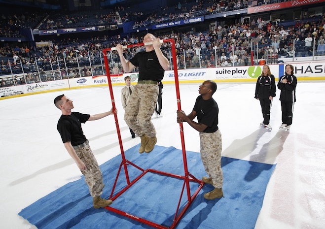 Gunnery Sgt. Brian P. Deiters performs one of 25 dead-hang pull-ups center-ice during the Marine Corps Pull-Up Competition at the Chicago Wolves Armed Forces Night at the All-State Arena in Rosemont, Ill. Deiters, a canvassing recruiter with Marine Corps Recruiting Station Chicago, Recruiting Substation Chicago Heights, won the competition in front of 9,636 fans in attendance. Deiters is a 32-year-old native of Carlyle, Ill.