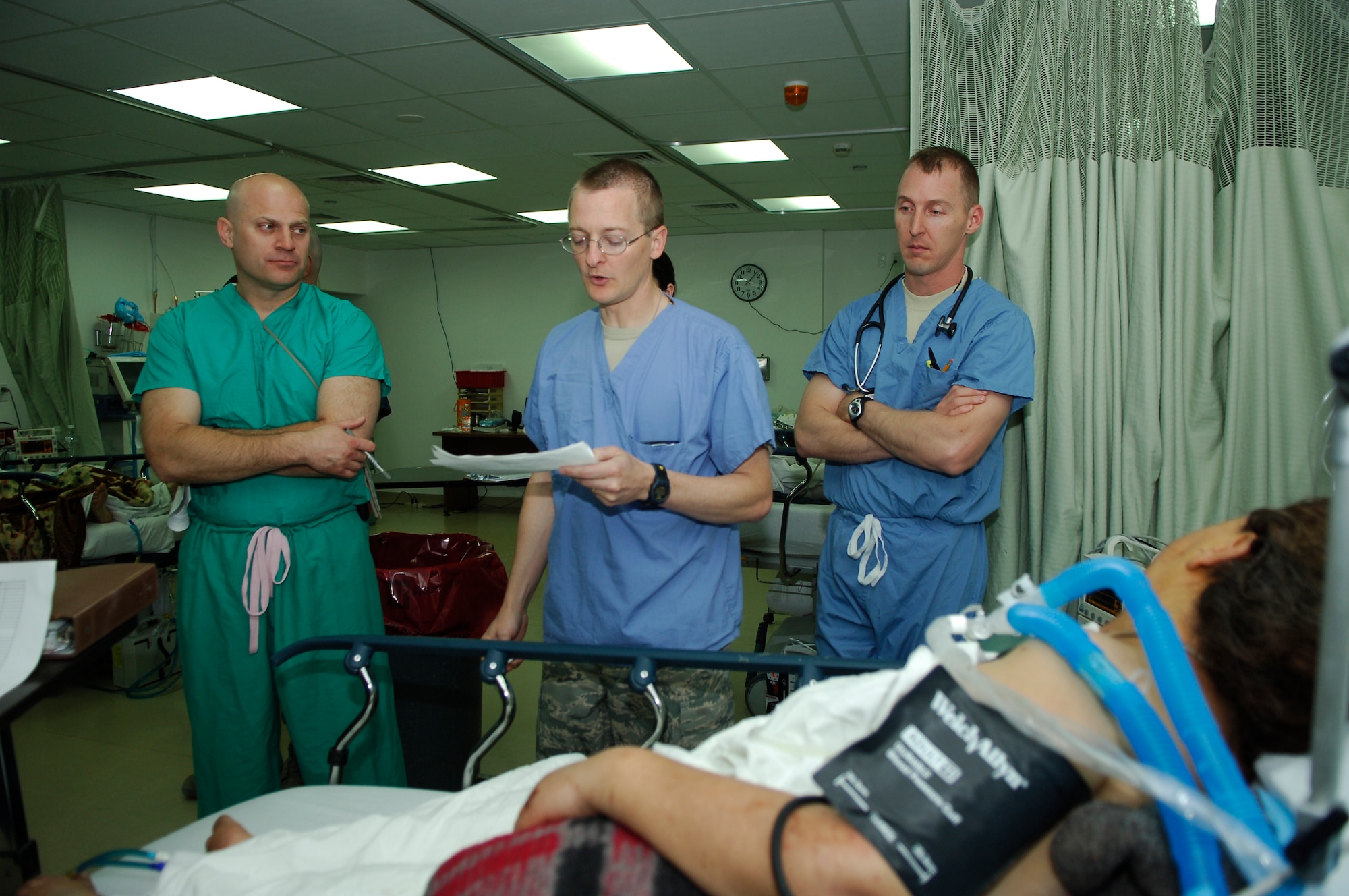 BALAD AIR BASE, Iraq - Maj. (Dr.) Eric Barnes, 332nd Expeditionary Medical Operations Squadron intensive care unit, briefs doctors during rounds on the condition of an Iraqi woman here, March 27. The trauma doctors performed rounds with the hospital staff after the Joint Theater Trauma System conference in order to observe how the Air Force Theater Hospital works. Doctor Barnes is deployed from Lackland Air Force Base, Texas. (U.S. Air Force photo / Staff Sgt. Mareshah Haynes) 