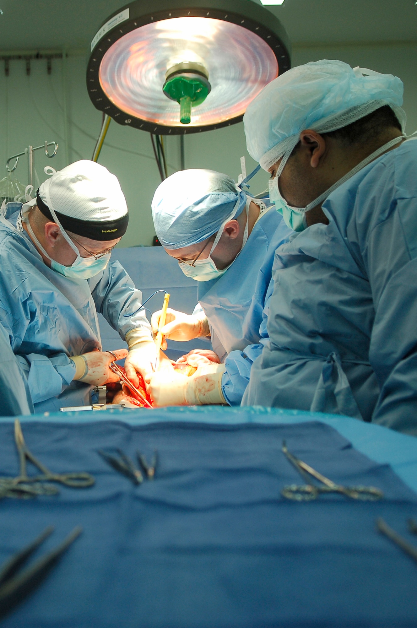 BALAD AIR BASE, Iraq -- Lt. Col. (Dr.) John Mansfield, 332nd Expeditionary Medical Operations Squadron urologist, Maj. (Dr.) Greg Hughes, 332nd EMDOS surgeon and an Iraqi surgeon from Balad General Hospital work together on a procedure to remove kidney stones from an Iraqi man here, March 26. The doctors met during the Joint Theater Trauma System conference where they learned how each other's medical facilities function. Doctor Mansfield is deployed from Royal Air Force Lakenheath, England and Doctor Hughes is deployed from Wright-Patterson Air Force Base, Ohio. (U.S. Air Force photo / Staff Sgt. Mareshah Haynes)