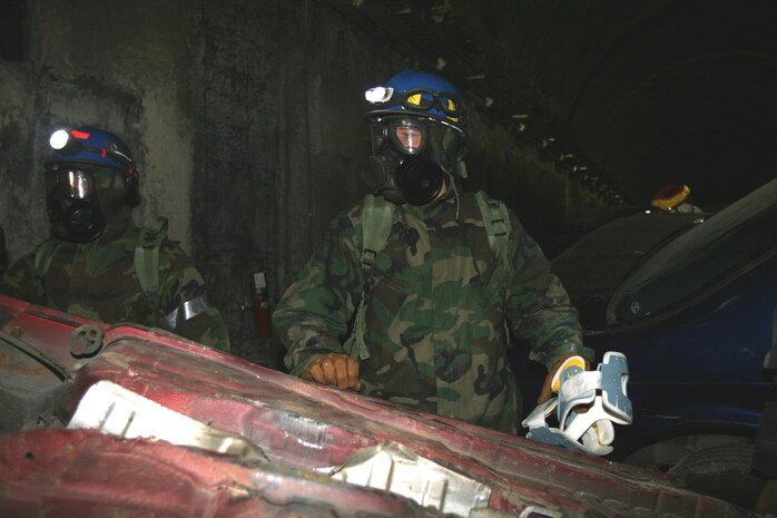 Petty Officers 3rd Class Jeshaun Kau (left) and Matthew Esper, both hospital corpsmen assigned to Headquarters and Service Company, Chemical Biological Incident Response Force, II Marine Expeditionary Force, rescue a casualty trapped in a car here March 29. Corpsmen are trained to provide medical care in a contaminated area while wearing personal protective equipment.