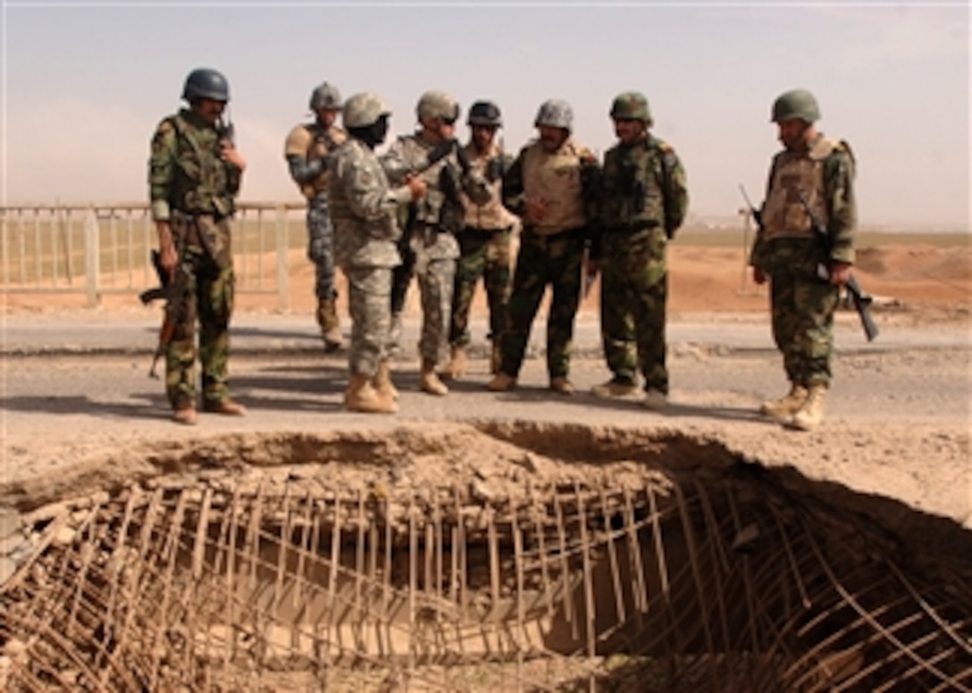 U.S. and Iraqi soldiers look over a bridge damaged by a vehicle borne improvised explosive device in Mosul, Iraq, March 22, 2008.