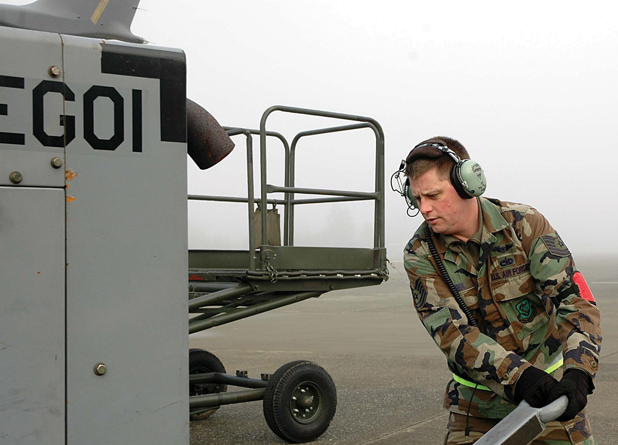 Tech. Sgt. Ray Green moves equipment into position while waiting for the morning fog to burn off at McChord Air Force Base, Wash., and clear the flightline so planes can take off.  Sergeant Green is an Air Force Reserve C-17 crew chief with the 446th Aircraft Maintenance Squadron here. (U.S. Air Force photo/Airman First Class Patrick Cabellon)