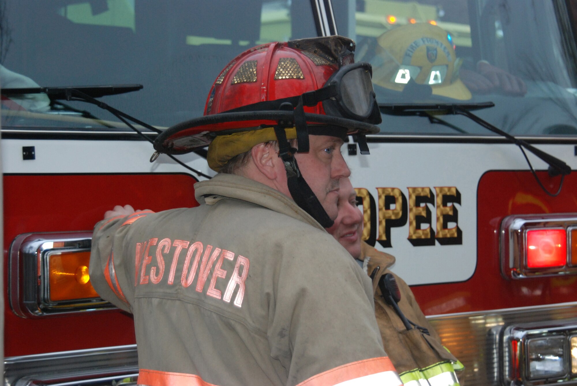 Westover firefighter Sean Strohman takes a break with a Chicopee firefighter on Mar. 28 after both units battled a fierce blaze along Interstate 91 in Chicopee, Mass. when a tractor-trailer carrying fuel, crashed into a guardrail earlier that morning.  The Chicopee fire department called in the Westover team because Westover?s specialized fire engines carry a foam used to fight fuel fires.(US Air Force photo/Maj. Jennifer Christovich)