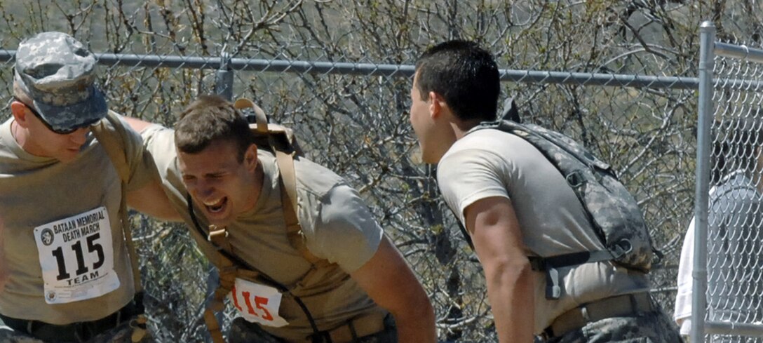 A struggling marcher in the Bataan Memorial Death March is helped toward the finish line by teammates March 30 at White Sands Missile Range, N.M. More than 4,400 runners and marchers participated in the 19th annual 26.2 or 15-mile run/walk. (U.S. Air Force photo/Greg Allen) 