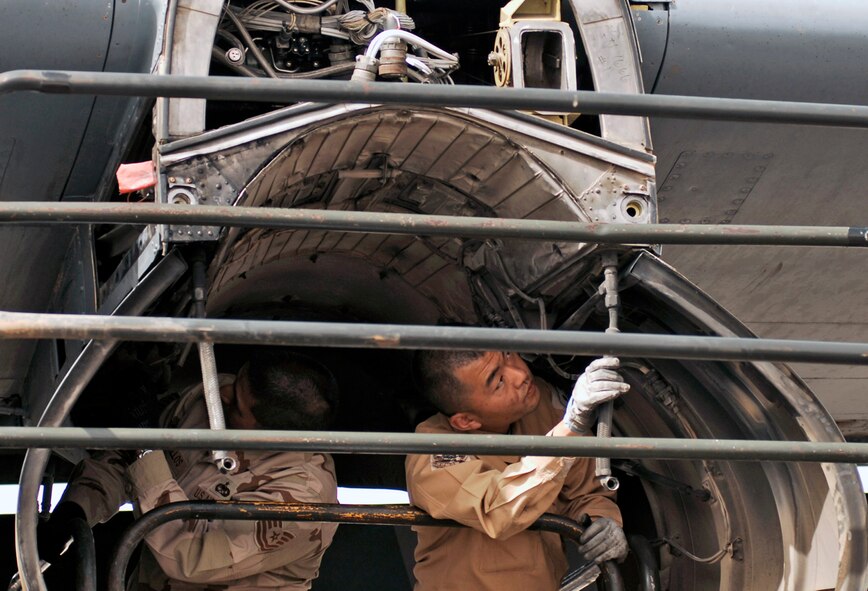 Tech. Sgt. Porfirio Bustillos (left) and Staff Sgt. Kouichi Tsunoda inspect an engine insulation blanket for cracks, holes and deterioration on a C-130 Hercules March 21 at a Southwest Asian air base. Airmen from the U.S., Japanese Air Self-Defense Force and South Korean air force's 58th Airlift Wing participated in a coalition maintenance exchange program allowing maintainers to sharpen their skills, exchange ideas, and promote closer relations among coalition air forces supporting the war on terrorism. Sergeant Bustillos is a maintainer deployed to the 386th Expeditionary Aircraft Maintenance Squadron, and Sergeant Tsunoda is a maintainer from the Japan Air Self-Defense Force Iraq Reconstruction Support Airlift Wing. (U.S. Air Force photo/Staff Sgt. Patrick Dixon) 