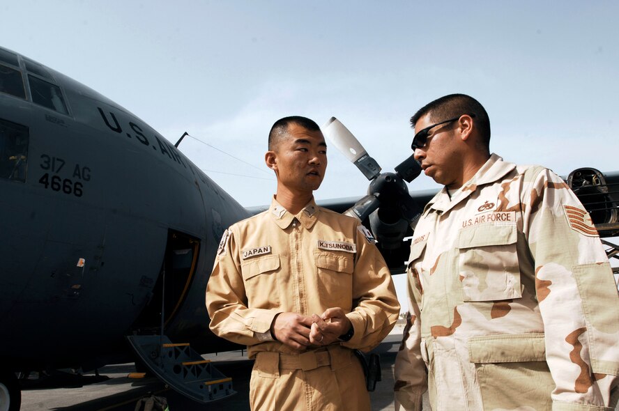 Japanese Staff Sgt. Kouichi Tsunoda (left) and Tech. Sgt. Porfirio Bustillos speak with each other before performing an inspection on an C-130 Hercules March 21 at a Southwest Asian air base. Airmen from the U.S., Japanese Air Self-Defense Force and South Korean air force's 58th Airlift Wing participated in a coalition maintenance exchange program allowing maintainers to sharpen their skills, exchange ideas, and promote closer relations among coalition air forces supporting the war on terrorism. Sergeant Tsunoda is a maintainer from the Japan Air Self-Defense Force Iraq Reconstruction Support Airlift Wing, and Sergeant Bustillos is a maintainer deployed to the 386th Expeditionary Aircraft Maintenance Squadron. (U.S. Air Force photo/Staff Sgt. Patrick Dixon) 