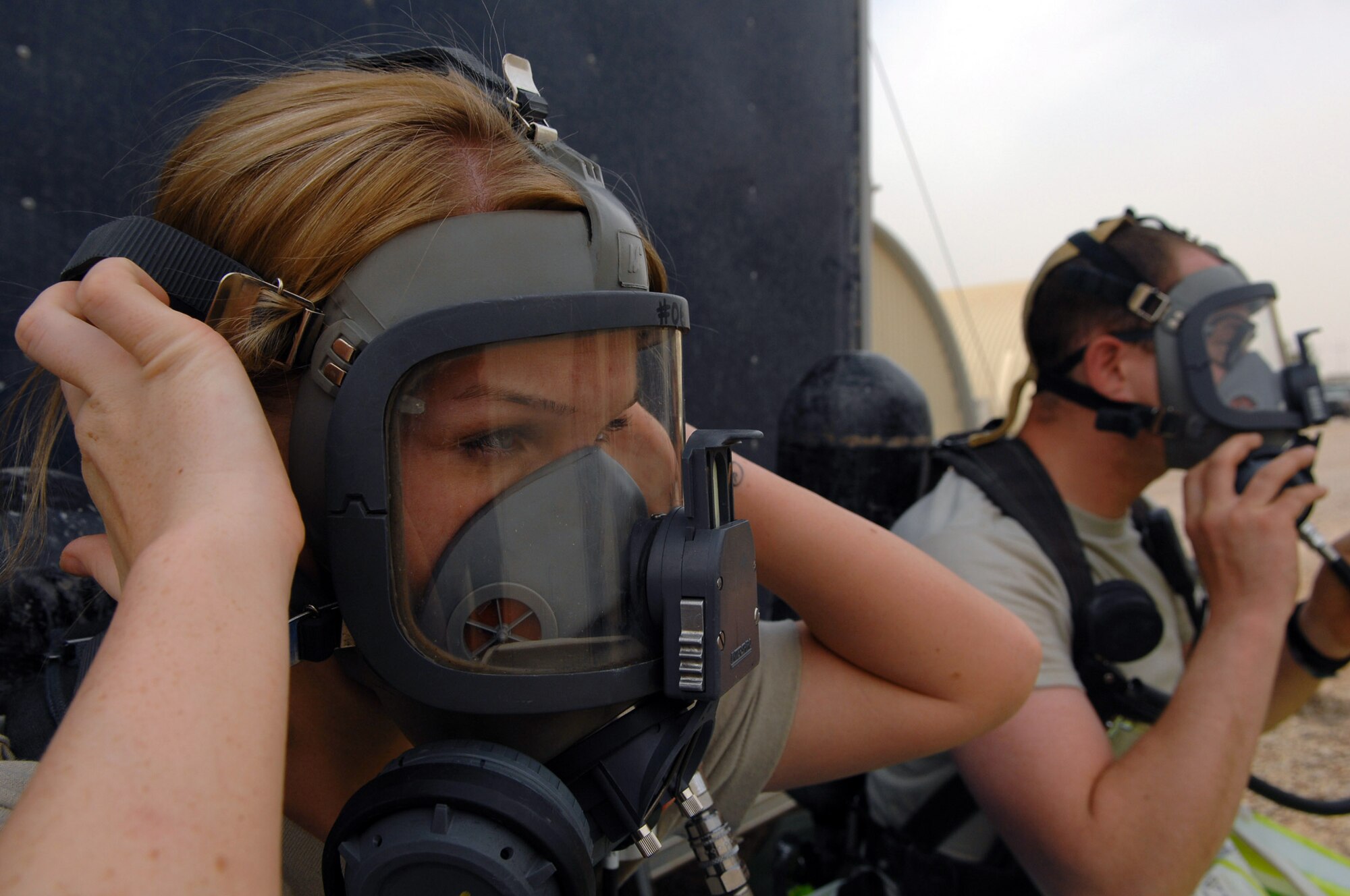 Senior Airman Krista McVicar practices tightening her oxygen mask March 26 at Balad Air Base, Iraq, during an emergency management drill. Emergency managers wear protective suits and breathe through air tanks to guard against chemical, biological, radiological or nuclear substances that may be present during a real-world attack. Emergency management Airmen conduct battle drills to keep their skills sharp and ensure they are familiar with wearing all the required gear. Airman McVicar is a 332nd Expeditionary Civil Engineer Squadron emergency manager deployed from Davis-Monthan Air Force Base, Ariz. (U.S. Air Force photo/Senior Airman Julianne Showalter) 

