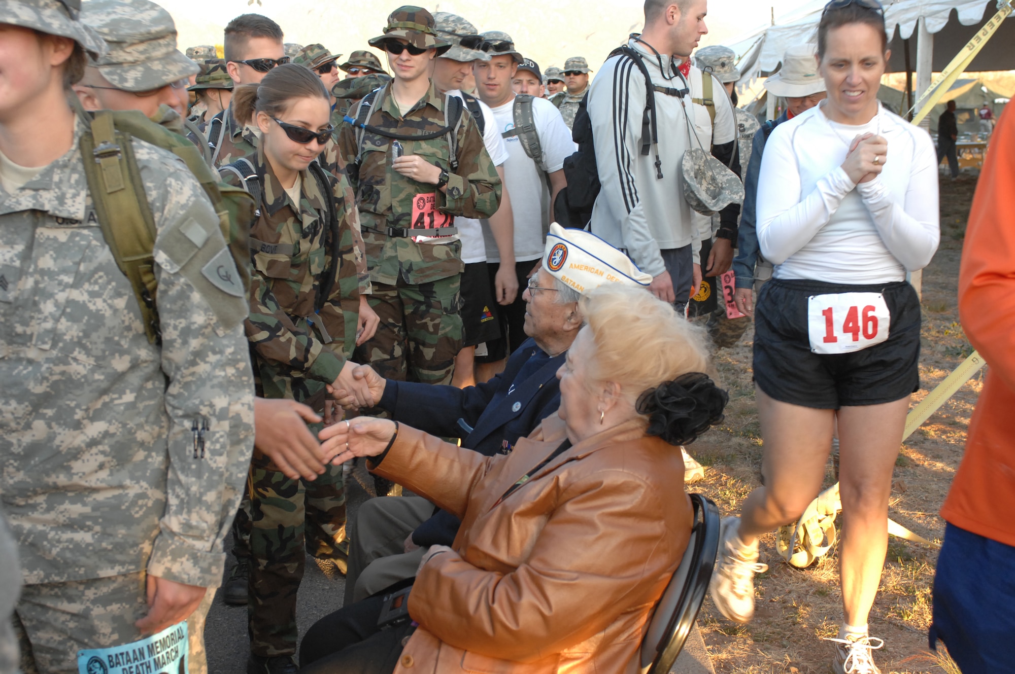 WHITE SANDS MISSILE RANGE, N.M. -- Battaan Death March survivor Carlos Montoya shakes hands with some of the more than 4,400 participants in the 19th Annual Bataan Death March Memorial Run on March 30. Military units from all 50 states as well as more than a dozen foreign countries gathered to honor the men who endured the death march in 1942 and prisoner of war hardships until 1945. (Air Force photo/Greg Allen)