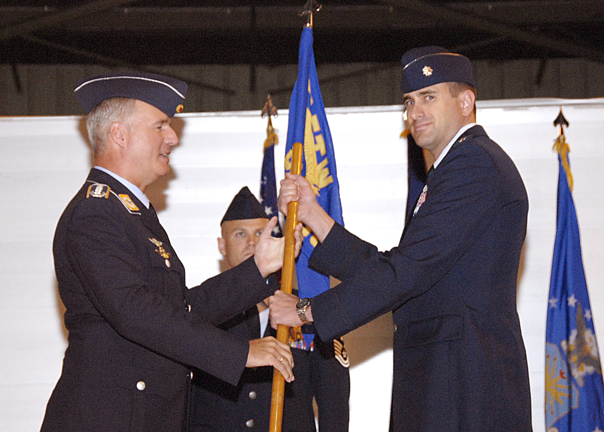 Incoming 80th Operations Support Squadron Commander Lt. Col. Michael Messer accepts the guidon from 80th Operations Group Commander Col. Axel Pohlmann March 28 during the squadron's change of command ceremony. Colonel Messer replaced Lt. Col. Joseph Less, who is headed for Germany to serve as a deputy group commander. (U.S. Air Force photo/Harry Tonemah)