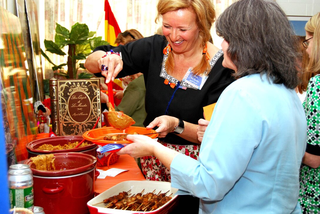 Petra Van Gaalen, left, prepares a meal from the Netherlands for Deborah Beasley March 28 at the 2nd Annual Taste of NATO at Sheppard Air Force Base's South Chapel. Mrs. Van Gaalen, wife of Lt. Col. Willem Van Gaalen, and other NATO spouses treated members of the Sheppard Officer's Spouses Club to authentic European dishes during the event. (U.S. Air Force photo/John Ingle)