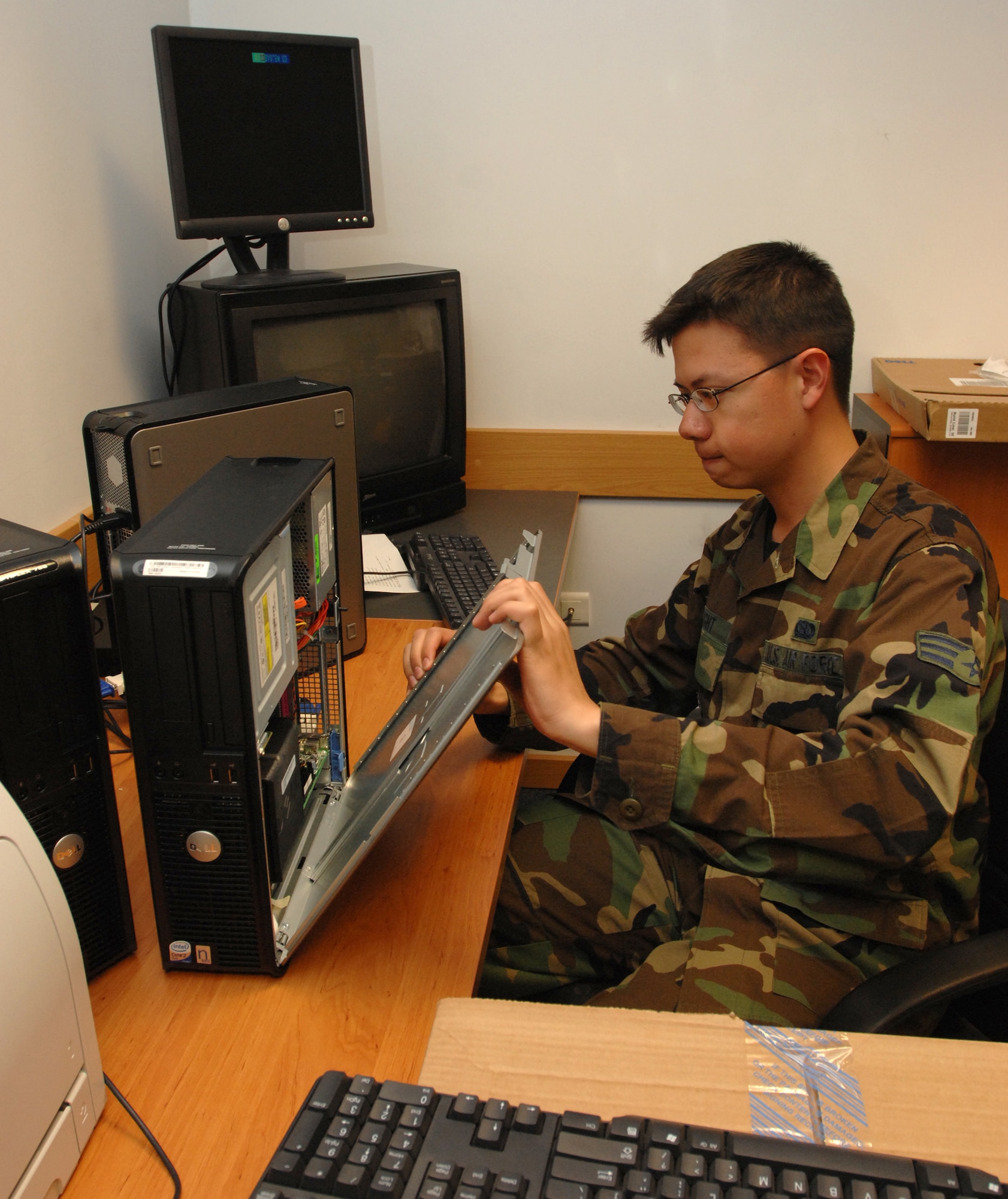 Senior Airman Joshua Wright, 39th Communications Squadron focal point customer service technician, puts a computer back together after completing tech-refresh actions for distribution throughout the wing. (U.S. Air Force photo by Senior Airman Heather Stanton)