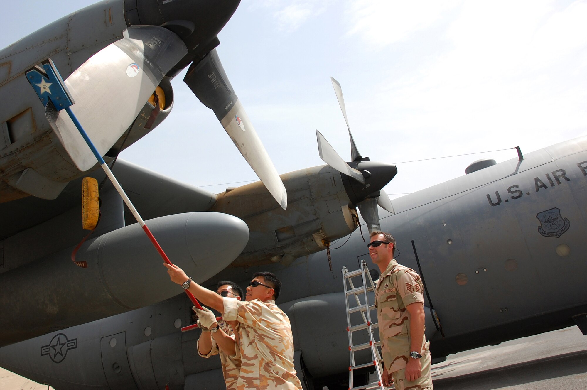 SOUTHWEST ASIA -- Warrant Officer Hae Ok Yoon (left) and Master Sgt. Jun Wan Park (center) use a prop stick to make sure the No. 1 blade is positioned in the T-position to prevent leaks on a U.S. Air Force C-130 Hercules while Staff Sgt. William Phillips watches March 26, 2008, on an air base in the Persian Gulf Region. Warrant Officer Yoon and Sergeant Park are from the Republic of Korea Air Force 58th Airlift Wing, and Sergeant Phillips is a crew chief deployed to the 386th Expeditionary Aircraft Maintenance Squadron. Airmen from the U.S. ROKAF, and Japan Air Self Defense Force Iraq Reconstruction Support Airlift Wing participated in a coalition maintenance exchange program allowing maintainers to sharpen their skills, exchange ideas, and promote closer relations among coalition air forces supporting the Global War on Terrorism. (U.S. Air Force photo/ Staff Sgt. Patrick Dixon)