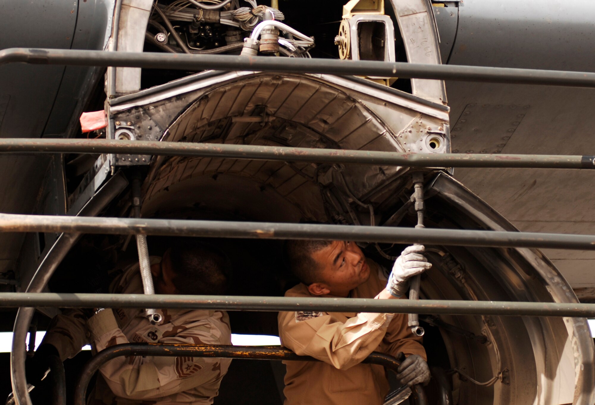 SOUTHWEST ASIA -- Technical Sgt. Porfirio Bustillos (left), a maintainer deployed to the 386th Expeditionary Aircraft Maintenance Squadron, and Staff Sgt. Kouichi Tsunoda, a maintainer from the Japan Air Self-Defense Force Iraq Reconstruction Support Airlift Wing Maintenance Squadron, inspect an engine insulation blanket for cracks, holes, and deterioration on an U.S. Air Force C-130 Hercules March 21, 2008, at an air base in the Persian Gulf Region. Airmen from the U.S., JASDF, and Republic of Korea Air Force 58th Airlift Wing participated in a coalition maintenance exchange program allowing maintainers to sharpen their skills, exchange ideas, and promote closer relations among coalition air forces supporting the Global War on Terrorism.  (U.S. Air Force photo/ Staff Sgt. Patrick Dixon)