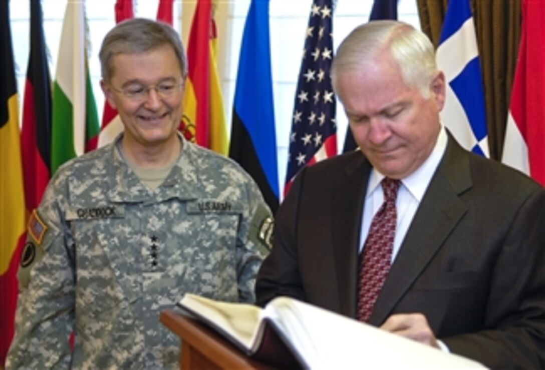 U.S. Army Gen. John Craddock, left, NATO's supreme allied commander Europe, watches as Defense Secretary Robert M. Gates signs a guest book at Supreme Headquarters Allied Powers Europe in Mons, Belgium, March 31, 2008.