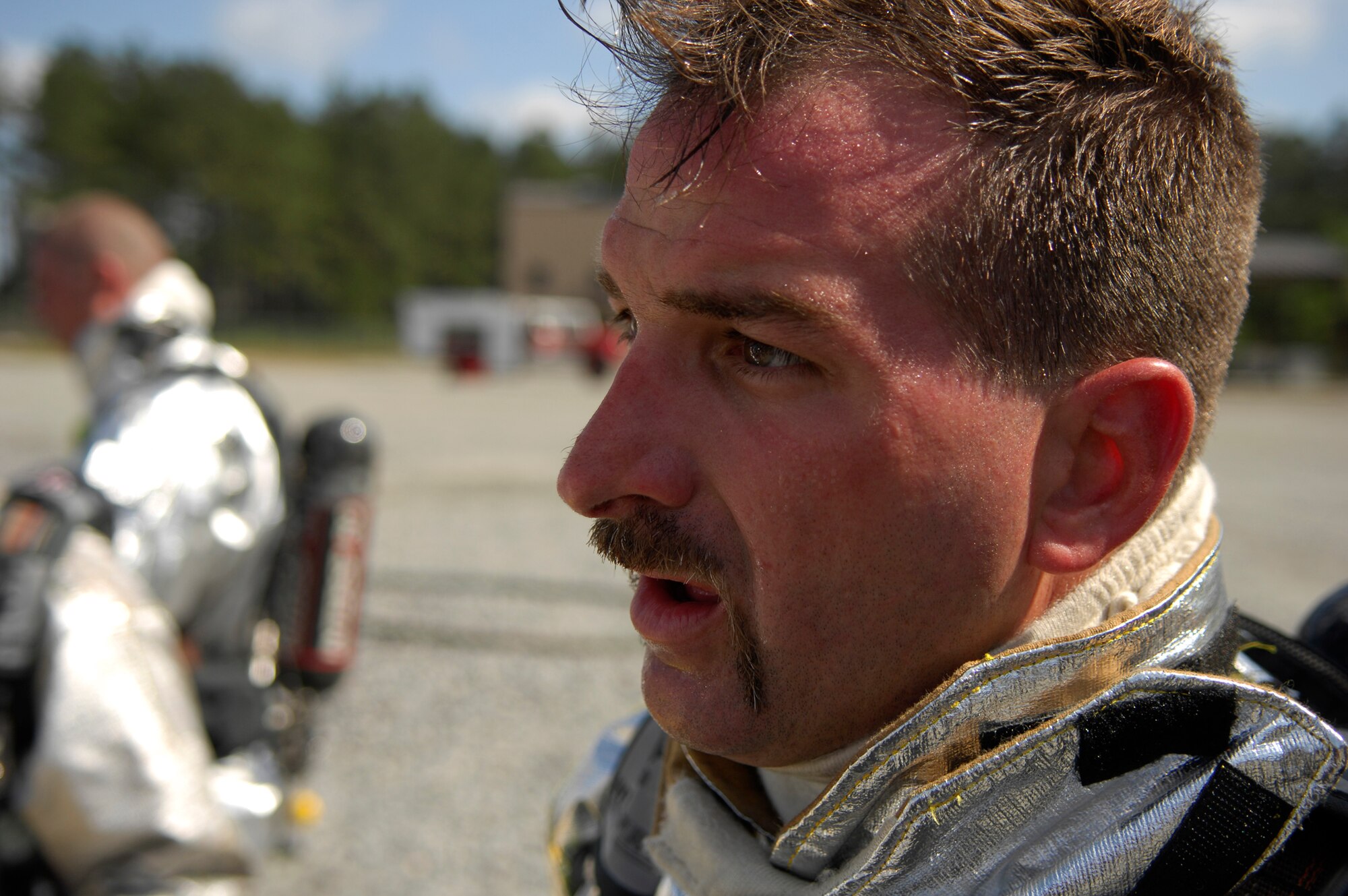 MOODY AIR FORCE BASE, Ga. -- Steve Wilmot, 23rd Civil Engineer Squadron Emergency Services Flight station captain, listens to an after-action briefing at Moody's aircraft fire trainer April 25.  Aircraft crash response firefighters are protected from the extreme heat of an aviation fire by reflective clothing and specialized breathing equipment  (U.S. Air Force photo by Tech. Sgt. Parker Gyokeres) 