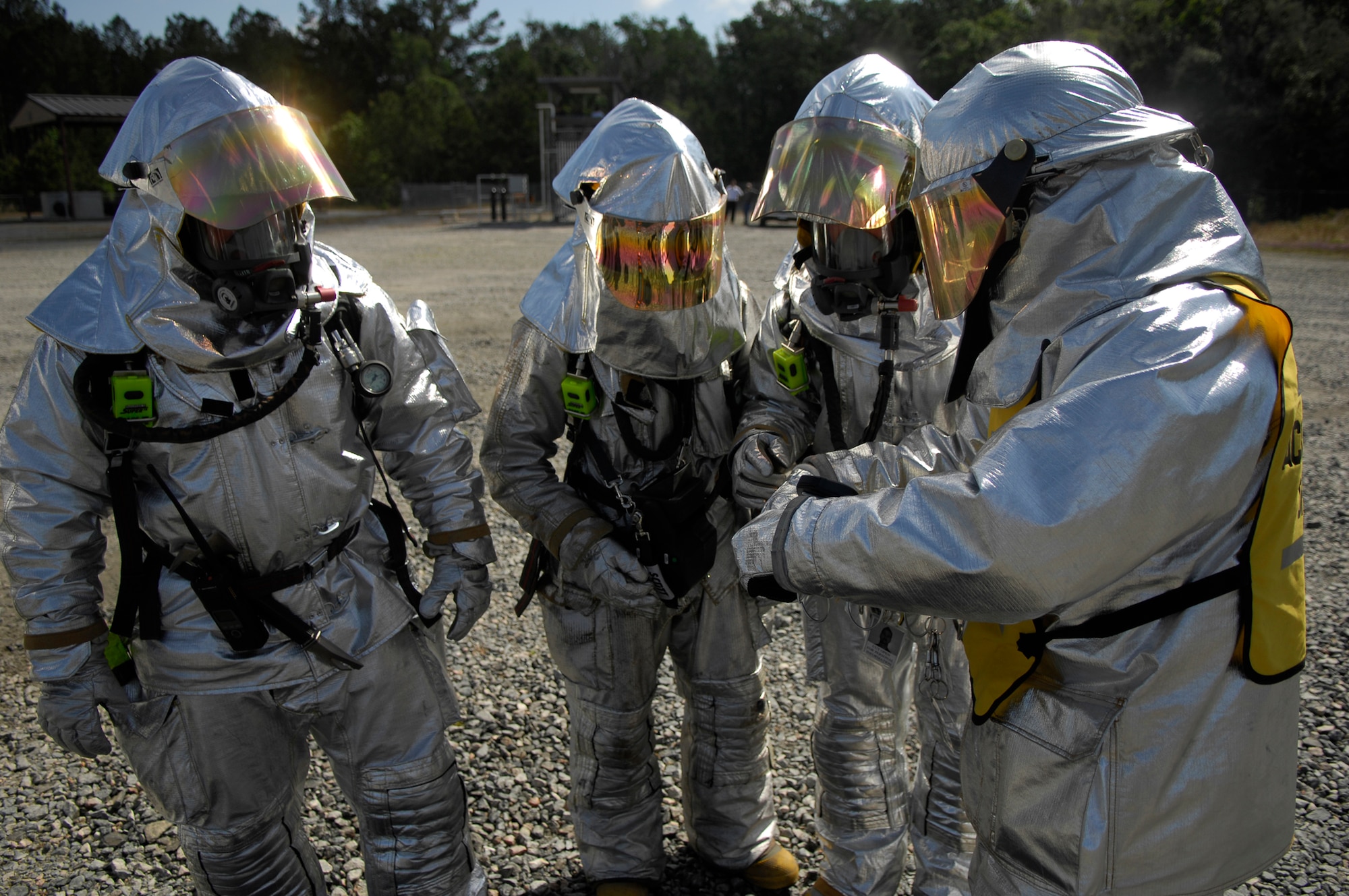MOODY AIR FORCE BASE, Ga. --  Firefighters from the 23rd Civil Engineer Squadron Emergency Services Flight discuss tactics for dealing with a scenario at the base's aircraft fire trainer April 25. The silver suits protect the rescue teams from the extreme heat of an aircraft fire.  (U.S. Air Force photo by Tech. Sgt. Parker Gyokeres) 