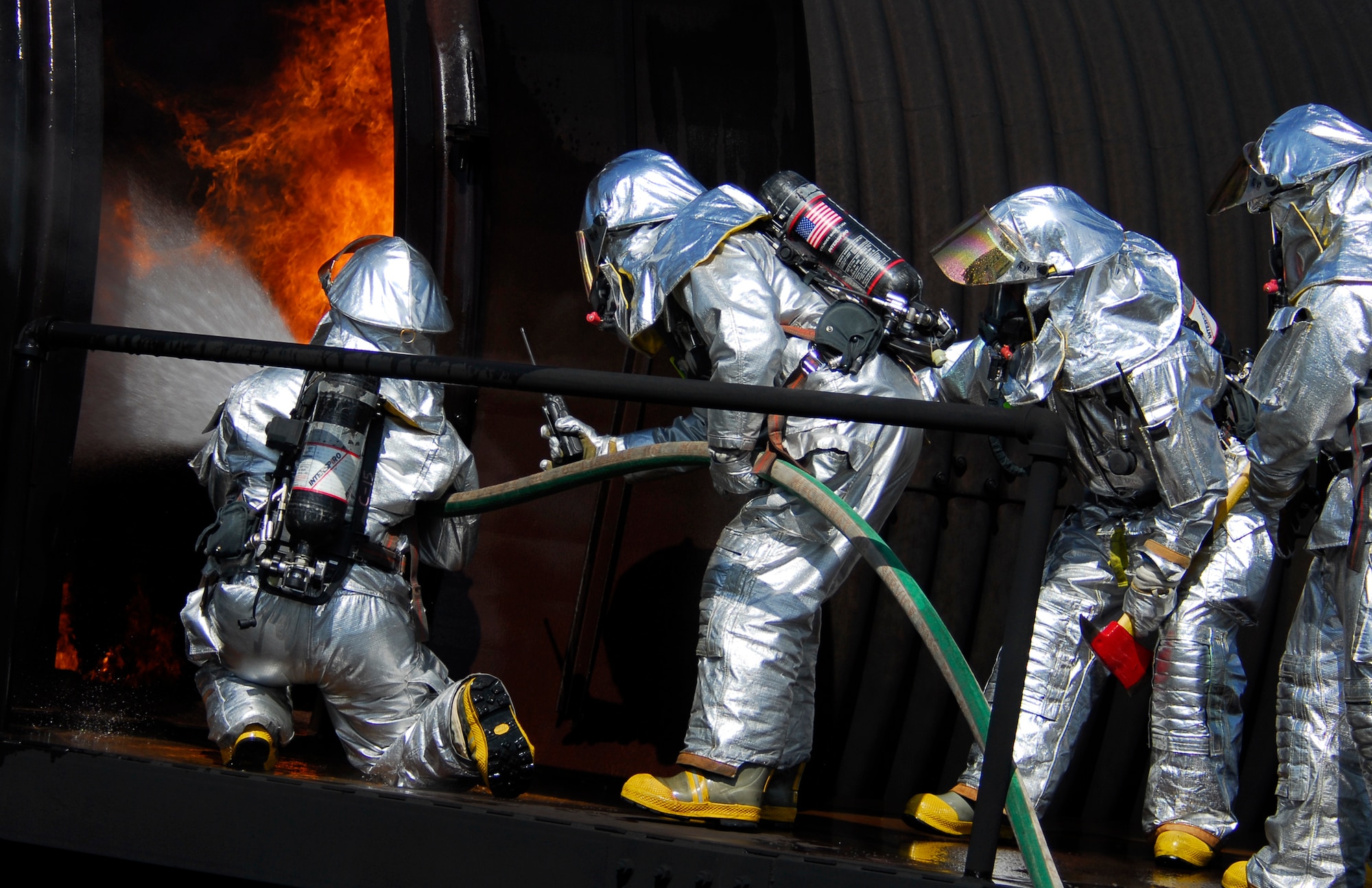 MOODY AIR FORCE BASE, Ga. -- Firefighters from the 23rd Civil Engineering Squadron Emergency Services Flight attack flames inside Moody's aircraft fire trainer April 25.  The facility uses propane gas jets to safely simulate a wide range of fire scenarios. (U.S. Air Force photo by Tech. Sgt. Parker Gyokeres) 