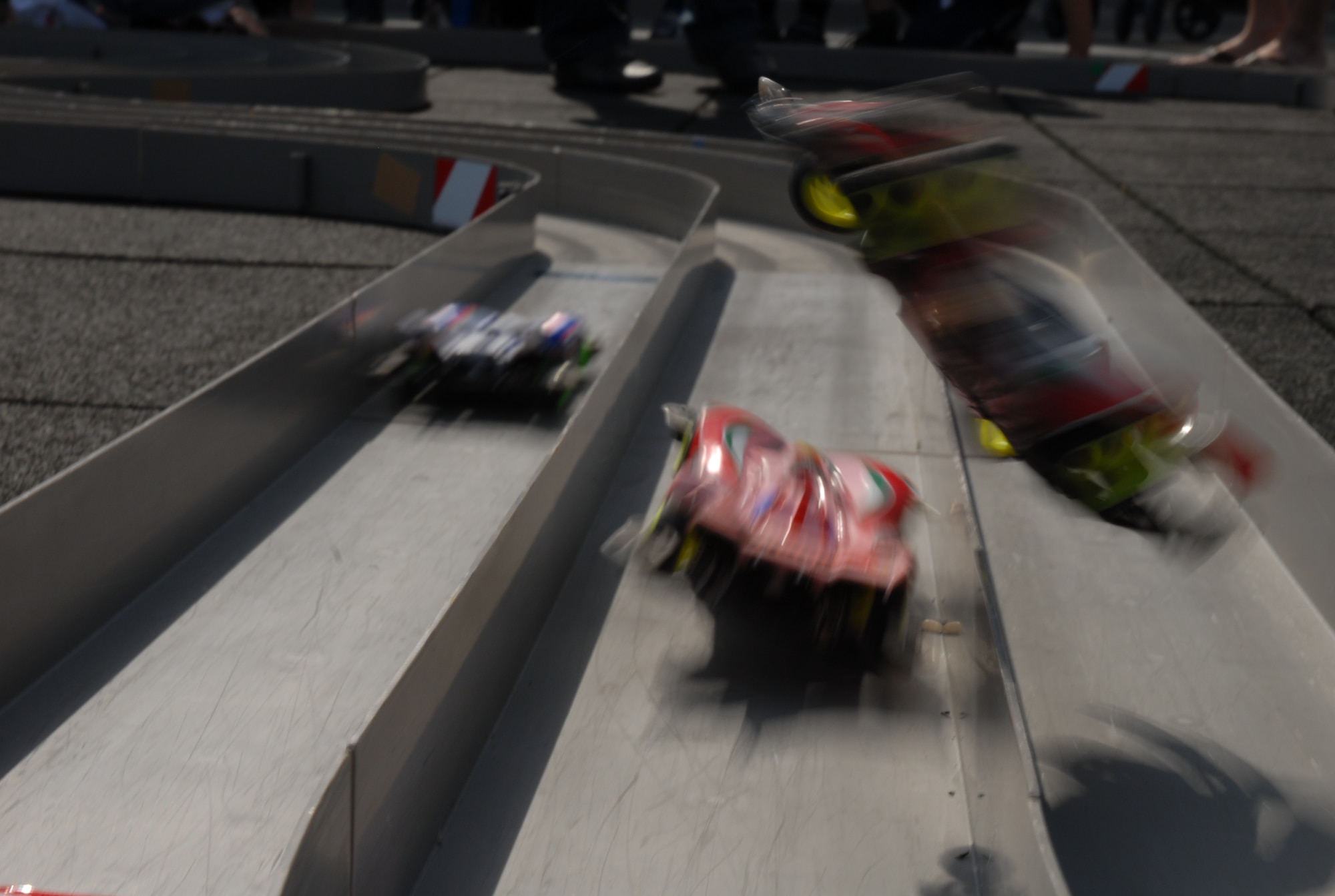 Battery-operated mini race cars zip through a race track at the Okinawa City Children’s Zoo April 27. More than 50 American and Okinawan children took part in the building and racing of the cars. (U.S. Air Force photo/Airman Chad Warren)