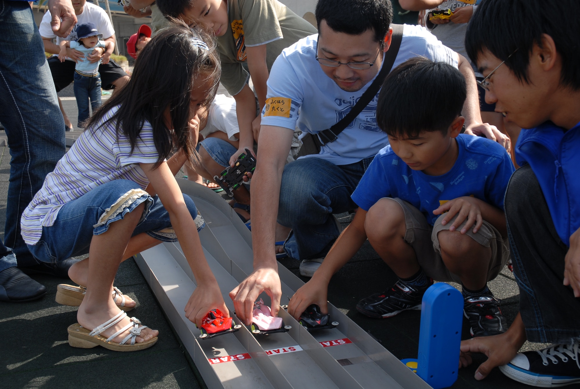 Participants position their cars at the starting line after building them in a workshop at the Okinawa City Children’s Zoo April 27. More than 50 American and Okinawan children took part in the building and racing of the battery-operated cars. (U.S. Air Force photo/Airman Chad Warren)