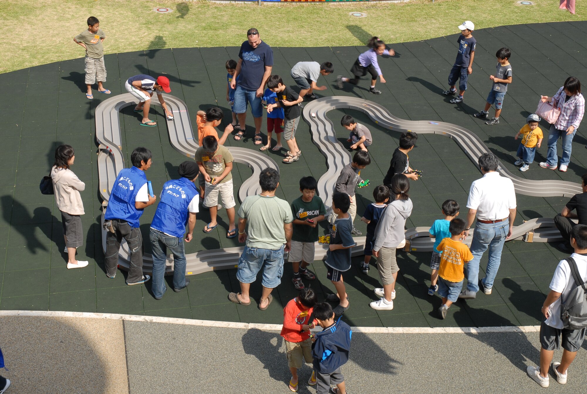 Spectators and competitors gather around the racetrack at the Okinawa City Children’s Zoo April 27. More than 50 American and Okinawan children took part in the building and racing of the battery-operated cars. (U.S. Air Force photo/Airman Chad Warren)