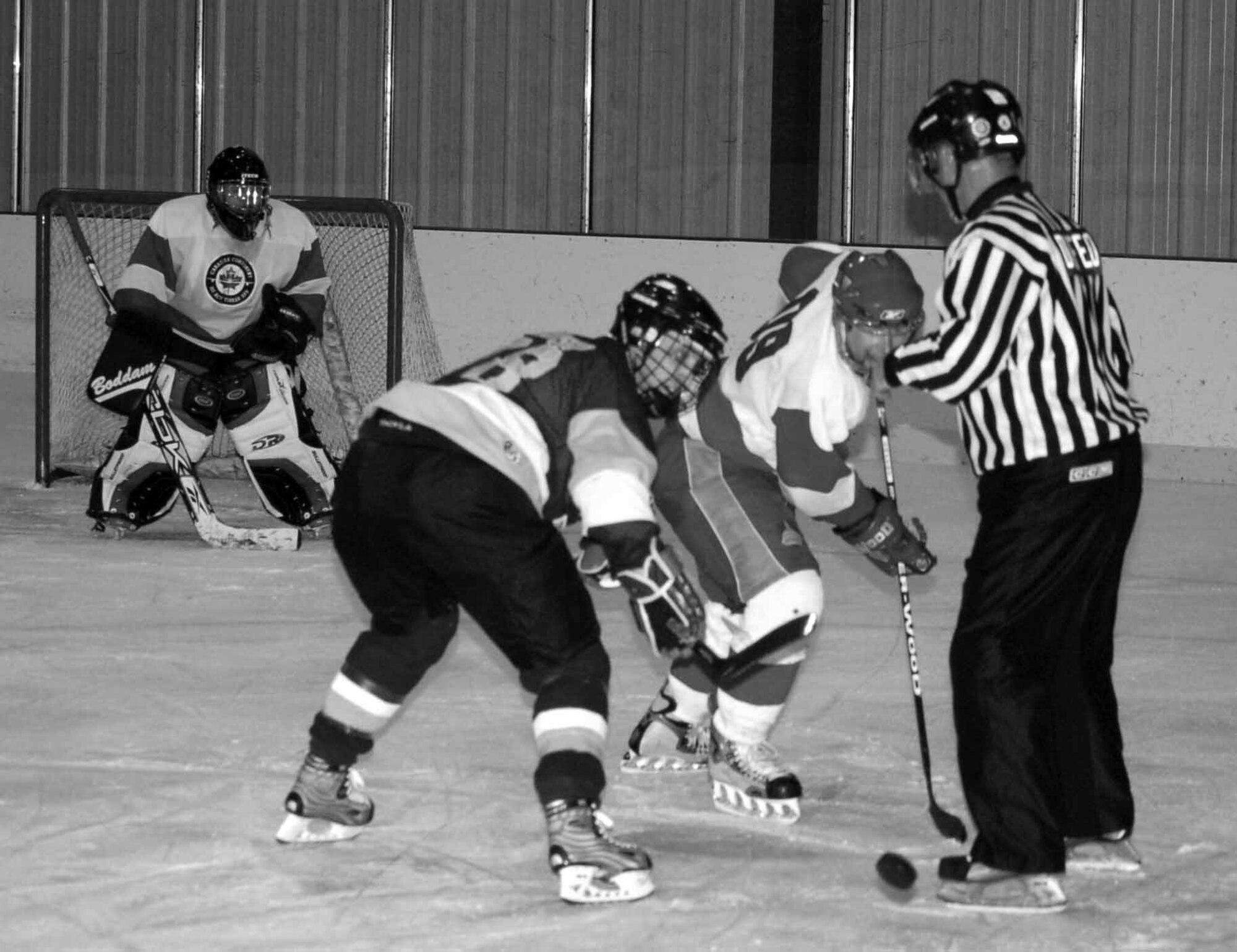 Tinker Hawks I forward (98) NIck Russo and Canadians A forward (09) Bill Chirch battle for the puck in the first period of a game at the Arctic Ice Edge Arena April 27. The Canadians won the game 6-1.  (Air Force photo by John E. Banks)