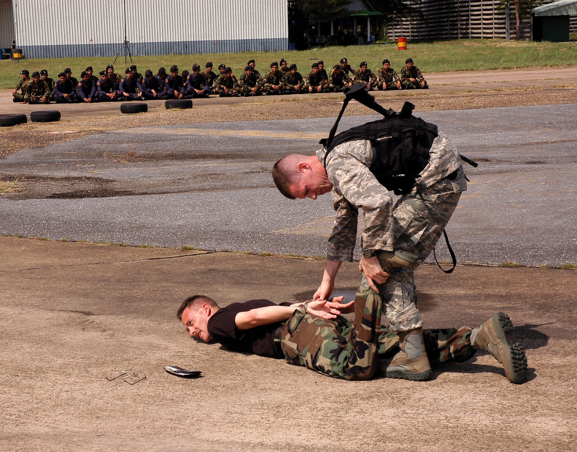 Staff Sgt. Richard Holder cuffs Tech. Sgt. Gregory Stout during exchange training with ground defense forces from Udon Thani, Thailand. Sergeant Holder is assigned to the 18th Security Forces Squadron at Kadena Air Base, Japan.  Sergeant Stout is assigned to the 353rd Special Operations Group security forces at Kadena AB. (U.S. Air Force photo/Master Sgt. Marilyn Holliday)                        