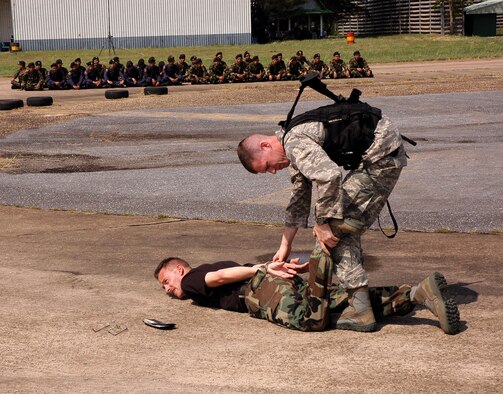 UDON THANI ROYAL THAI AIR BASE, Thailand -- Staff Sgt. Richard Holder cuffs Tech. Sgt. Gregory Stout during exchange training with ground defense forces from here. Sergeant Holder is assigned to the 18th Security Forces Squadron at Kadena Air Base, Japan. Sergeant Stout is assigned to the 353rd Special Operations Group security forces at Kadena. (U.S. Air Force photo/Master Sgt. Marilyn Holliday)
