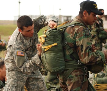 Army 1st. Lt. Robert Judge from the 509th Airborne Battalion checks the parachute equipment of a Honduran soldier before a combined jump with U.S. and Honduran military members April 30. The jump was the final event of a week-long Key Leader Exchange. (U.S. Air Force photo by Tech. Sgt. John Asselin)