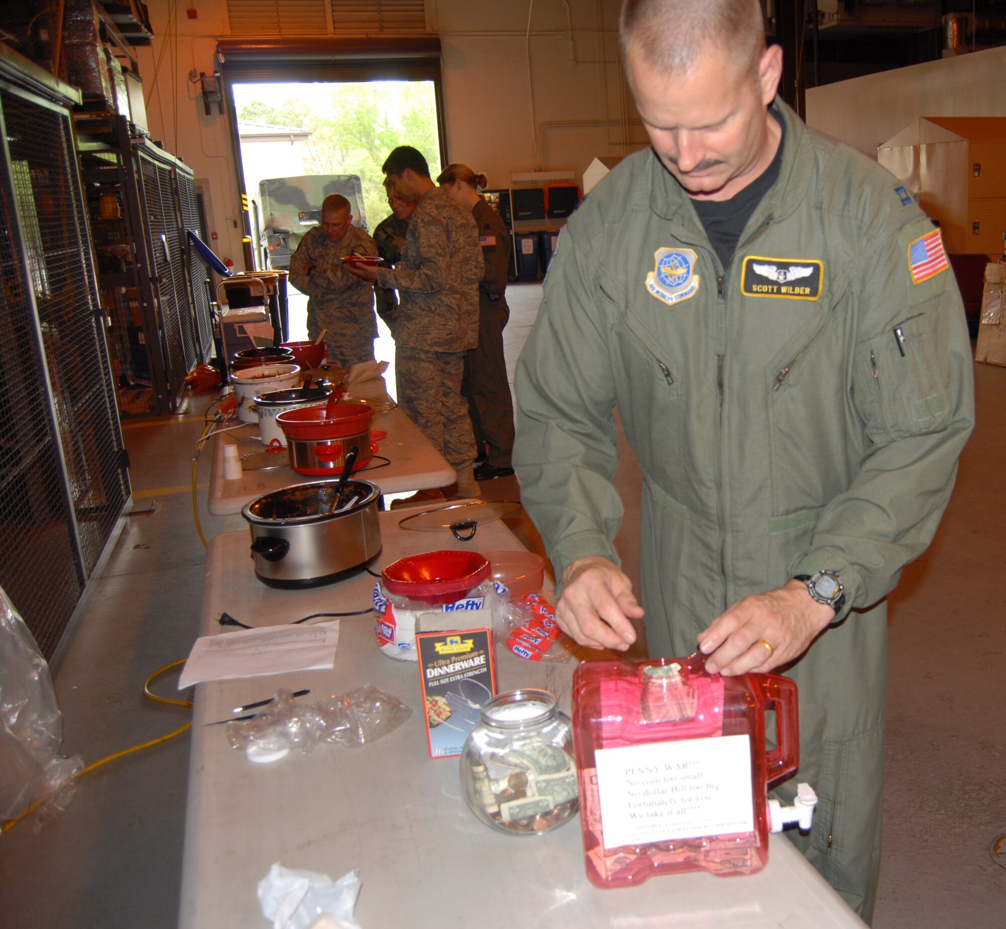 Capt. Lewis Wilber, 43rd Aeromedical Evacuation Squadron, puts away some of the $150 raised for the Air Force Assistance Fund April 23 from the squadron’s chili cookoff. He’s also wearing a moustache as part of a contest that also raised $200 for the AFAF. (U.S. Air Force Photo by 2nd Lt. Chris Hoyler)