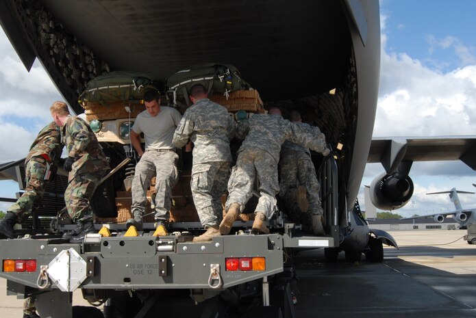 Pope Airmen and Fort Bragg Soldiers help push a HUMVEE off of a 3rd Aerial Port Squadron 60K loader driven by Airman 1st Class Leonid Ridel, 3rd APS, and onto a McChord Air Force Base, Wash. C-17 April 22 on Green Ramp. C-17s from McChord and Charleston Air Force Base, S.C. and C-130s from Dyess Air Force Base, Texas and Little Rock Air Force Base, Ark. joined Pope’s planes on Green Ramp throughout the week for a joint forces exercise. (U.S. Air Force Photo by 2nd Lt. Chris Hoyler)