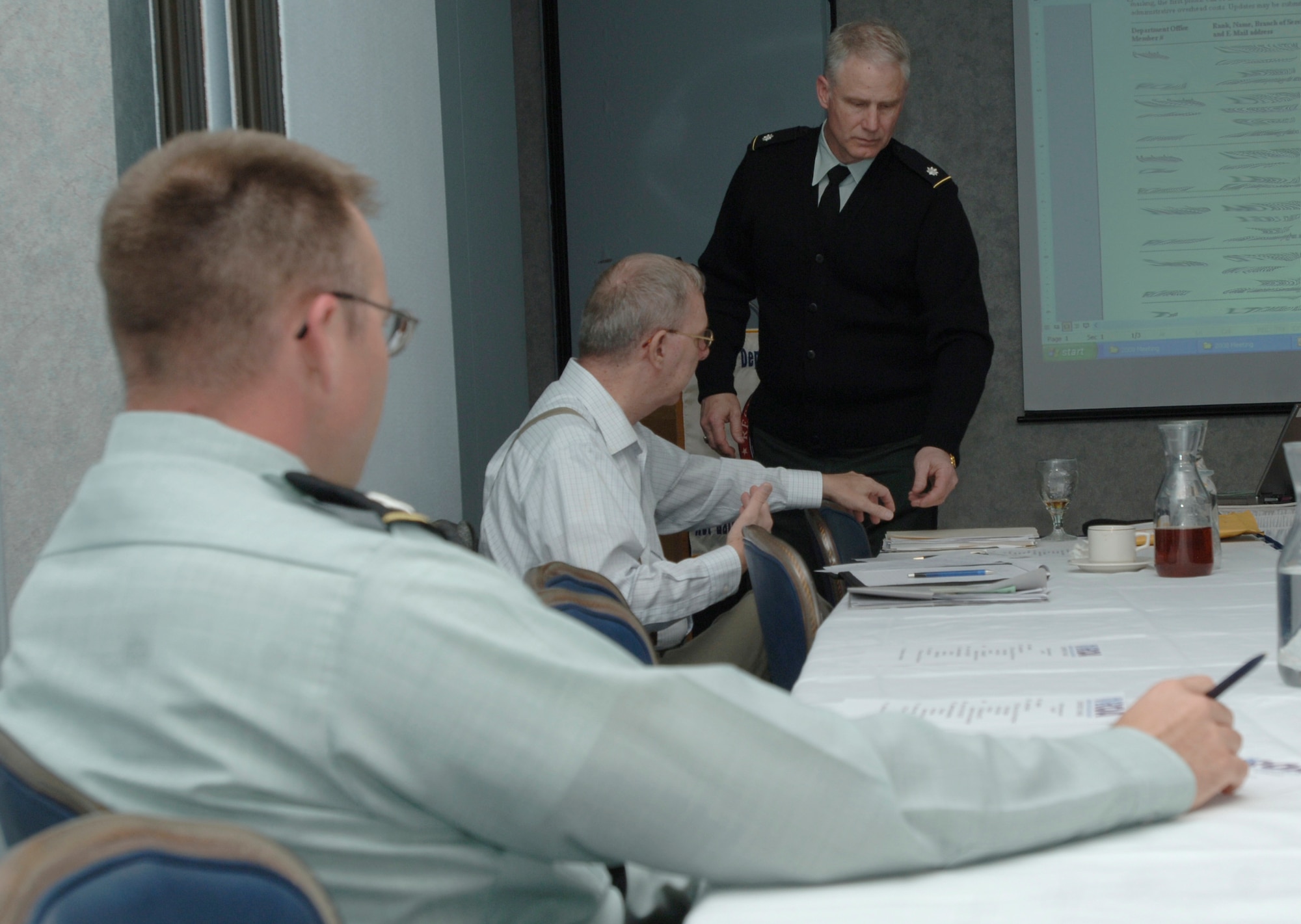 MCCONNELL AIR FORCE BASE, Kan. -- Lt. Col. Steven Layton, 89th Regional Readiness Command, hands retired Lt. Col. Bud Huffman information on this years Reserve Officers Association State Convention at the Robert J. Dole Community Center, April 26. The Reserve Officers Association maintains Reserve and National Guard resources and training for national defense. (Photo by Senior Airman Roy Lynch III)