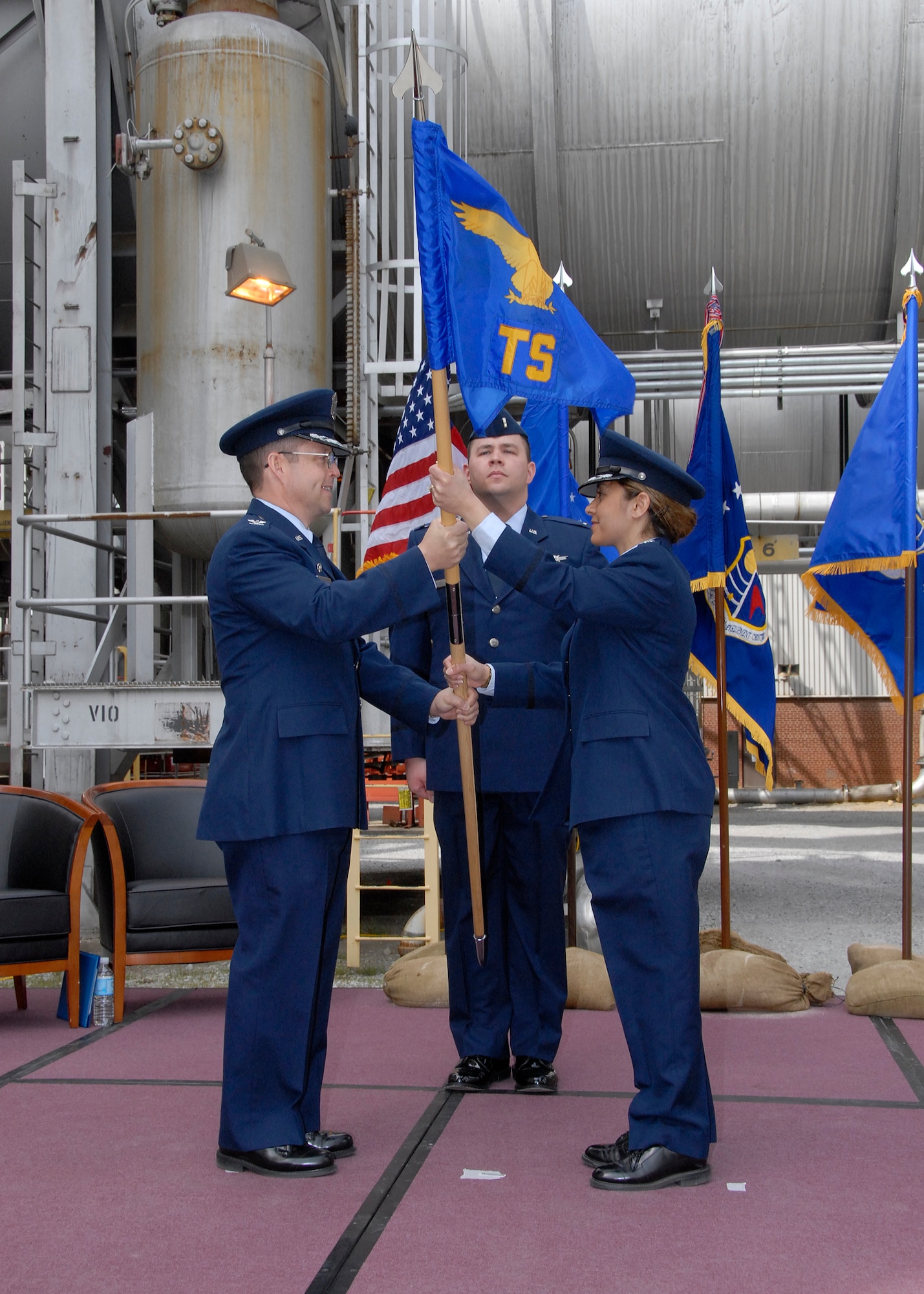 Col. James Jolliffe, commander of the 704th Test Group at Arnold Engineering Development Center, Arnold Air Force Base, Tenn., passes the flag of the 716th Test Squadron to Lt. Col. Vanessa L. Bond during a change of command ceremony here April 18, 2008. The ceremony took place between the 16-foot transonic and 16-foot supersonic wind tunnels. Lt. David Cancel is also pictured. As commander of the 716th, Colonel Bond, who took command from Col. William Hack, will direct sophisticated flight simulation testing for air and space systems in subsonic to hypersonic flight envelopes. In her previous assignment, Colonel Bond served as student leader for more than 30 officers and civilians in her class at the Air Force Institute of Technology at Wright-Patterson Air Force Base, Ohio, where she worked on her doctorate degree. There she studied aeroelasticity and multi-disciplinary optimization. Her research included conducting subsonic wind tunnel testing at the Portuguese Air Force Academy and static nonlinear response testing at the University of Manchester, UK. As a graduate of the USAF Test Pilot School in Class 98A, Colonel Bond served as a flight test engineer on multiple weapon systems including the F-15E, C-130E/H/H2/P and C-5. Most recently, Colonel Bond served as an assistant airector of Operations for the 411th Flight Test Squadron during the developmental flight test program for the F-22 Raptor.