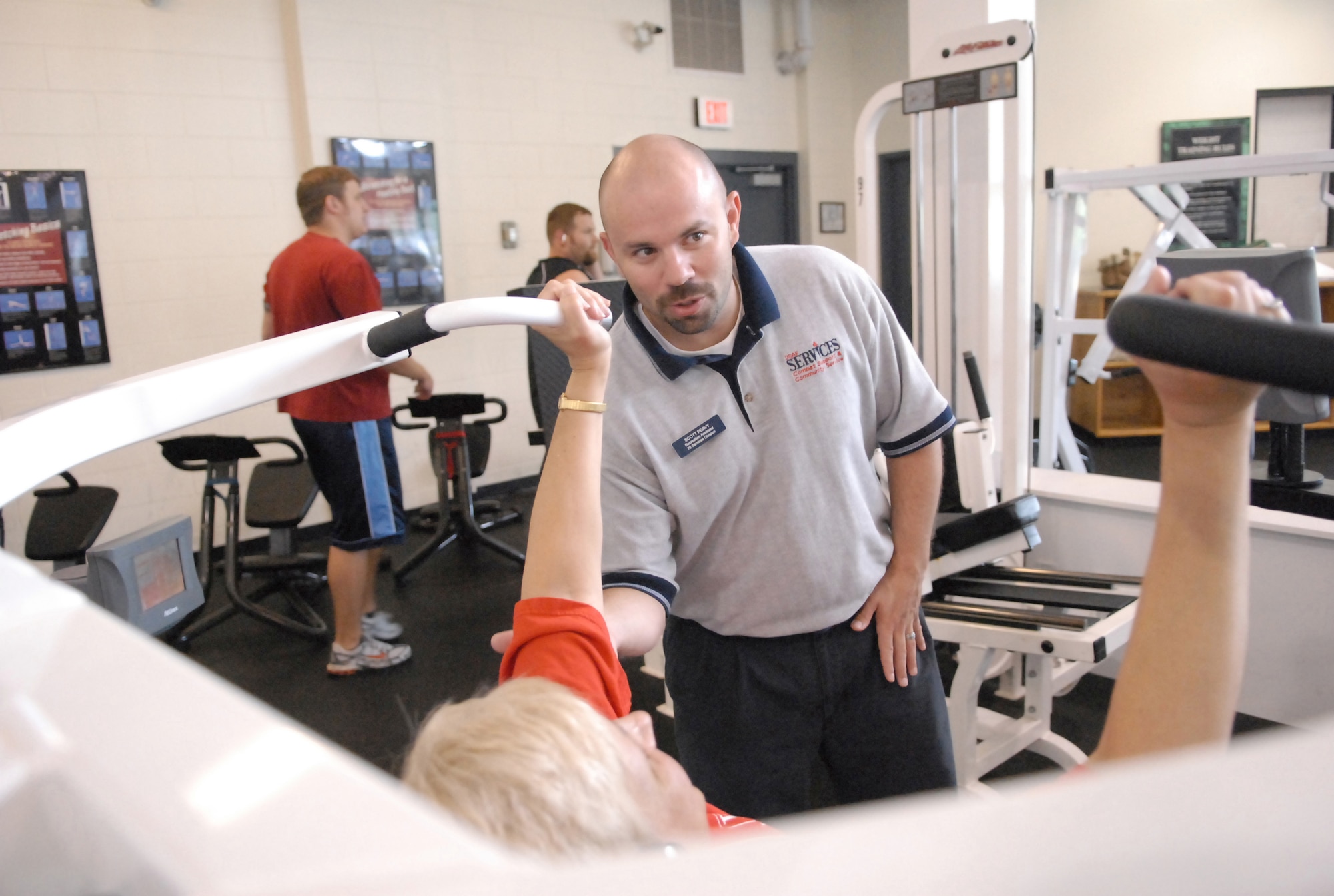 Scott Peavy, a recreational assistant at the Fitness Center, works with a patron. Mr. Peavy is one of six personal trainers who help patrons get the most out of their workouts. U. S. Air Force photo by Raymond Crayton