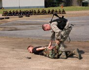 Staff Sgt. Richard Holder, 18th Security Forces Squadron, cuffs Tech. Sgt. Gregory Stout, 353rd Special Operations Group security forces, during exchange training with ground defense forces from Udon Thani, Thailand (in background). (U.S. Air Force photo/Master Sgt. Marilyn Holliday)                        
