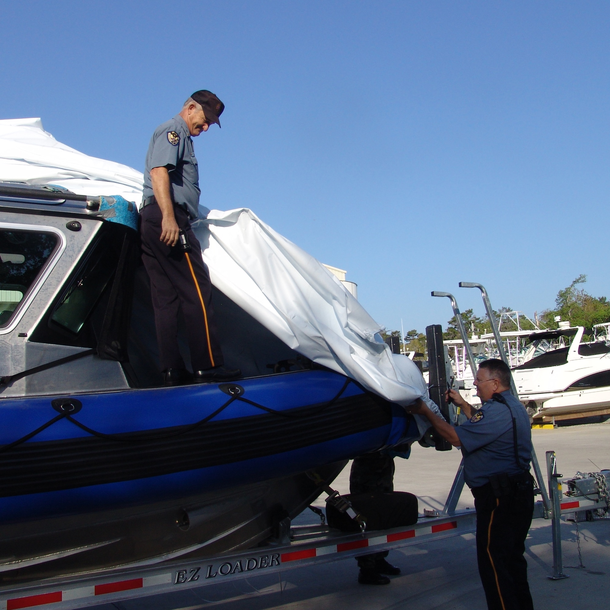 Chief Jerry Brown and Capt. Robert Bendus, 96th Security Forces Squadron, unveil the squadron's latest weapon in force protection, a 25-foot patrol boat.  (USAF photo by Lois Walsh)   