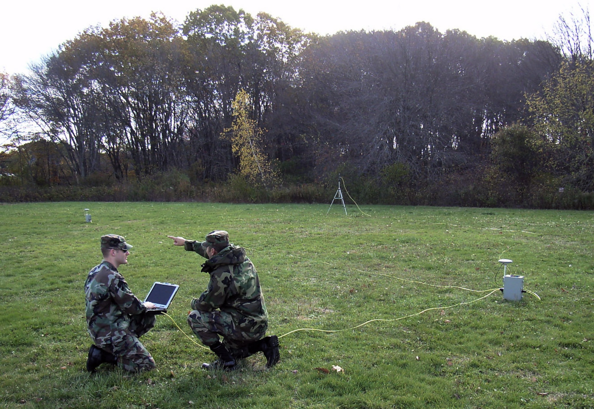 First Lt. Pat Ris (left) and 1st Lt. Juan Gherardy set up a portable version of the Joint Precision Approach Landing System outside Hanscom Air Force Base, Mass. The equipment, which can be carried in two rucksacks, consists of two GPS antennas and receivers, a ruggedized notebook computer, networking hardware and an aircraft data link.  (U.S. Air Force photo)