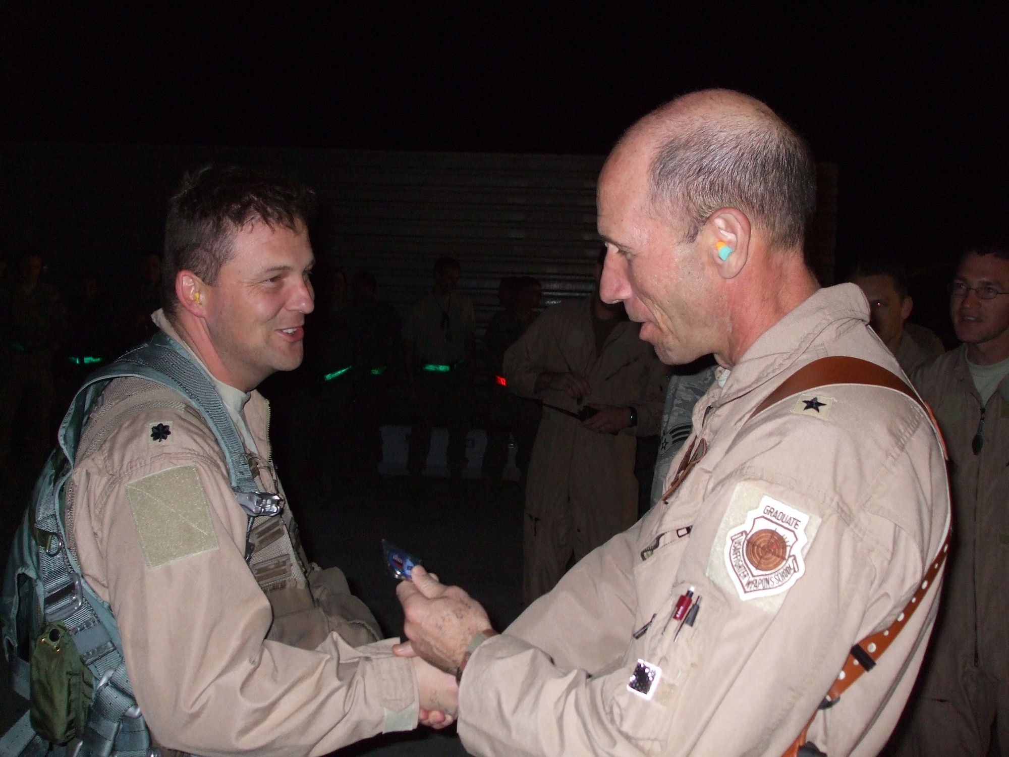 BAGRAM AIR FIELD, Afghanistan -- Lt. Col. Travis “Flak” Willis is congratulated by Brig. Gen. Mike Holmes, 455th Air Expeditionary Wing commander, after returning from a mission here.  Colonel Willis reached 1,000 combat hours March 31 while flying his 335th mission while deployed with the 335th Expeditionary Fighter Squadron.  (Courtesy Photo)
