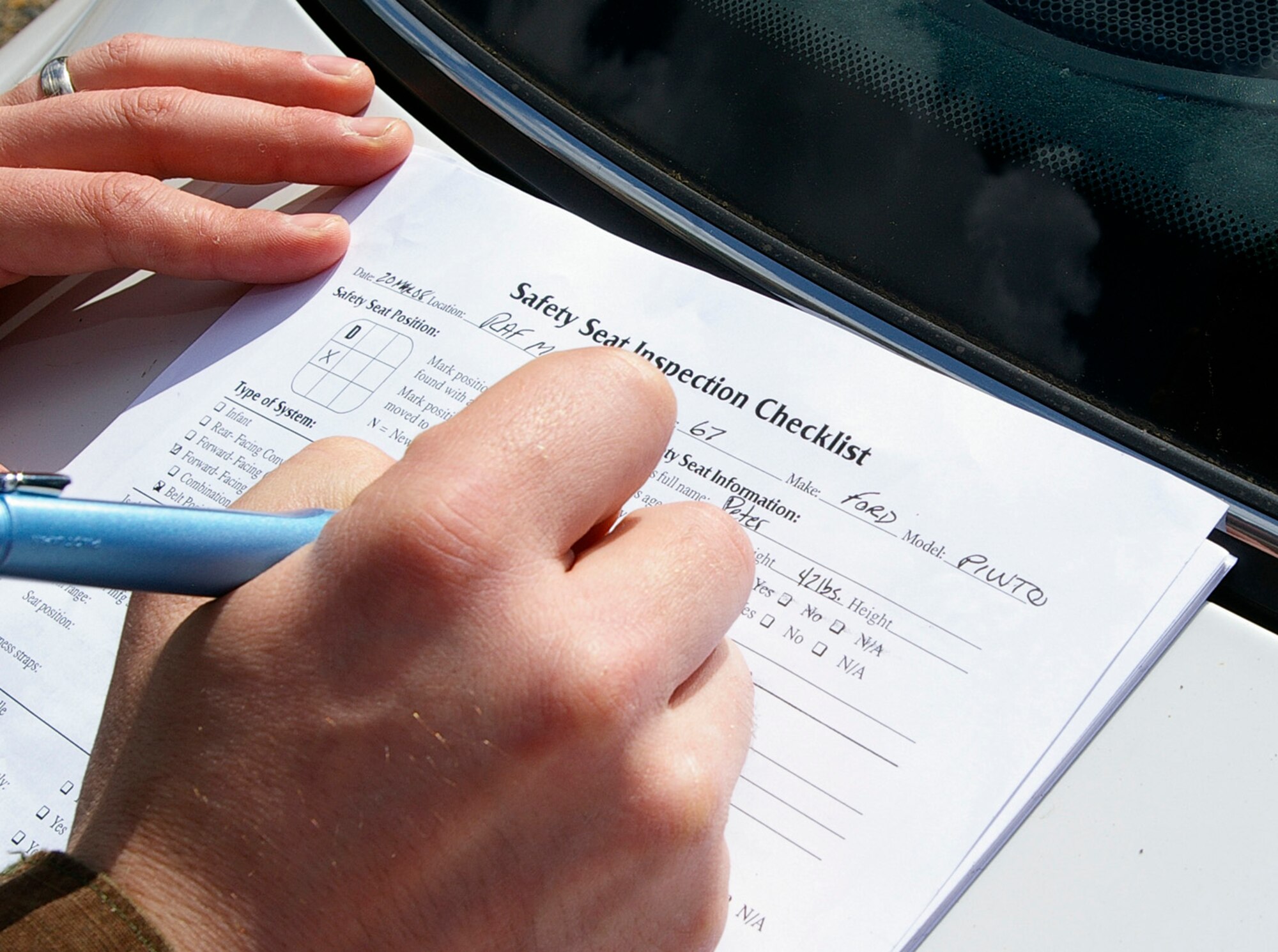 When helping parents to correctly install their child car seats, members from the 100th Civil Engineer Squadron Fire Department complete a thorough checklist. This contains details of the vehicle, including locations of air bags and seatbelts, and off the car seat. After receiving intense training, firefighters are helping parents ensure they have the correct car seat for their children's size, weight and age, as well as providing them the confidence to install it correctly themselves. (U.S. Air Force photo by Karen Abeyasekere)