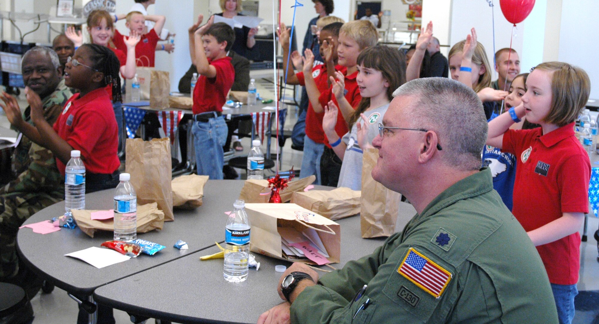 Lieutenant colonel Walther Koelln, 700th Airlift Squadron commander, watches as children sing and dance at the Mount Paran Christian school military breakfast April 23. The children, along with help from their teachers, coordinated the annual service event. The children decorated brown paper bags and filled them with treats for the dozen Airmen who attended.