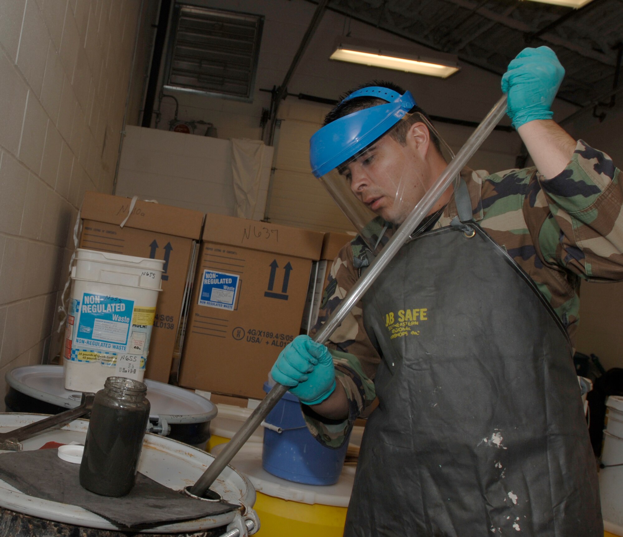 MCCONNELL AIR FORCE BASE, Kan. -- Senior Airman Hector Vaca-Flores, 22nd Aerospace Medicine Squadron, uses a coliwasas to take hazard waste sample from a drum at Hazardous Material, April 29. Coliwasas is used to get a sample then is left into the hazardous material for it is now contaminated.   (Photo by Senior Airman Roy Lynch III)