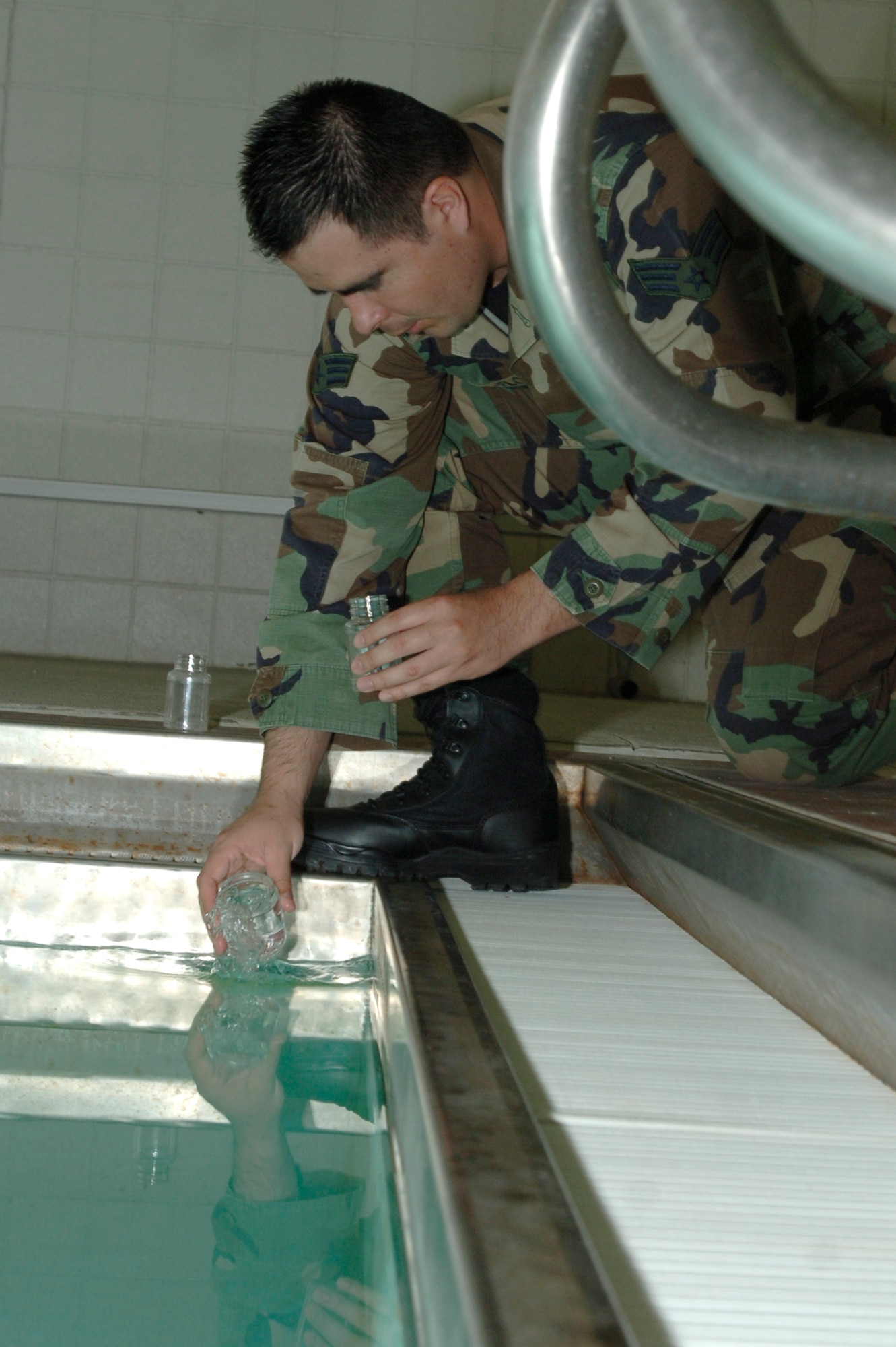 MCCONNELL AIR FORCE BASE, Kan. -- Senior Airman Hector Vaca-Flores, 22nd Aerospace Medicine Squadron, collects samples from the indoor pool at the Robert J. Dole Community Center, April 29. The mission of Bioenvironmental Engineering is to provide operational health risk assessment expertise to enhance commander decision making and health service support capabilities. (Photo by Senior Airman Roy Lynch III)