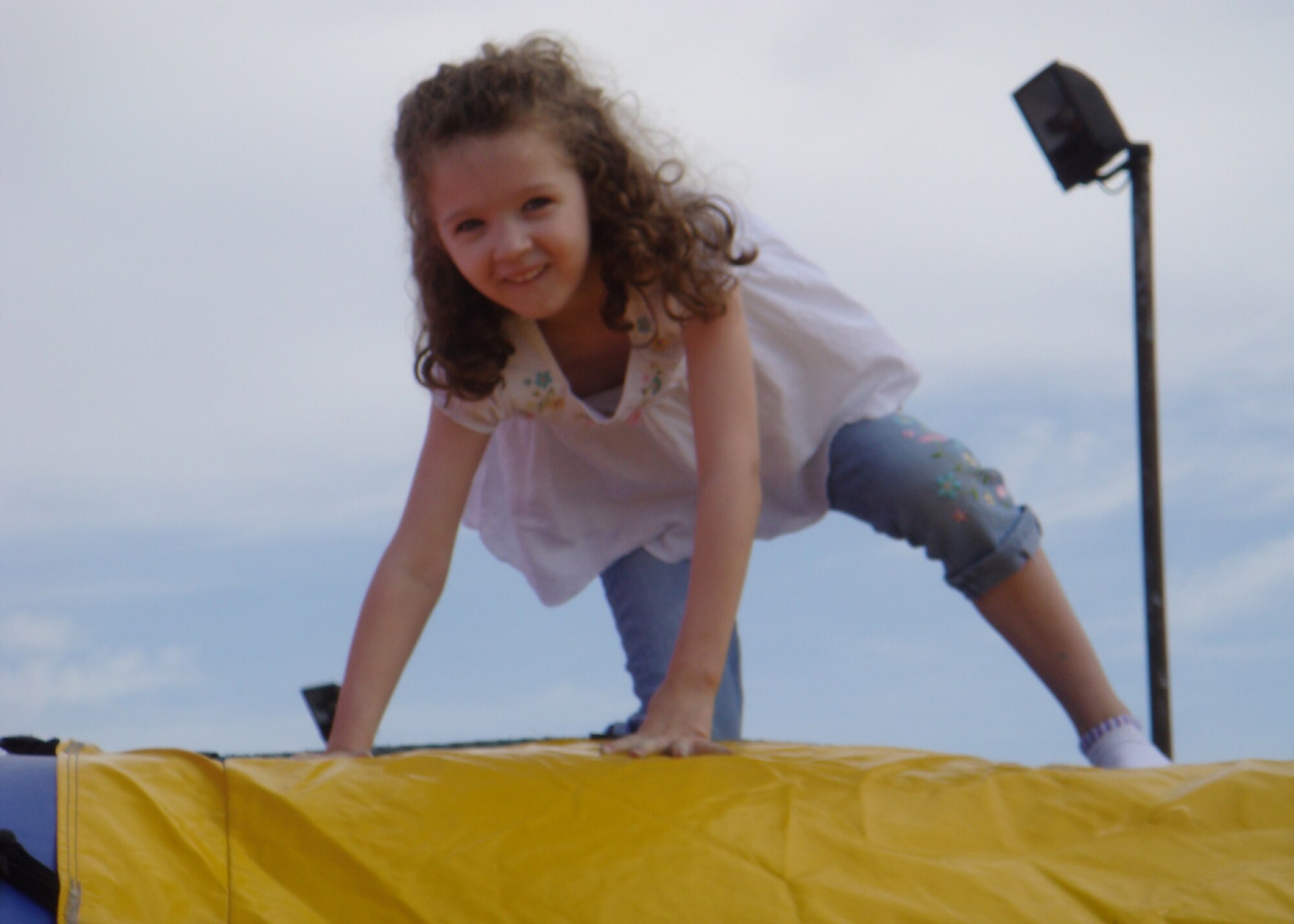 Trinity Cabuto makes it to the top of an air-filled jungle gym at the Military Child Fair April 26 at RAF Lakenheath, England. Liberty Airmen and their families were invited to celebrate military children during the fair at the Lakenheath Youth Center. Activites included face painting, a rock wall, bouncy castles and arts and crafts. (U.S. Air Force photo by Airman 1st Class Torri Ingalsbe)
