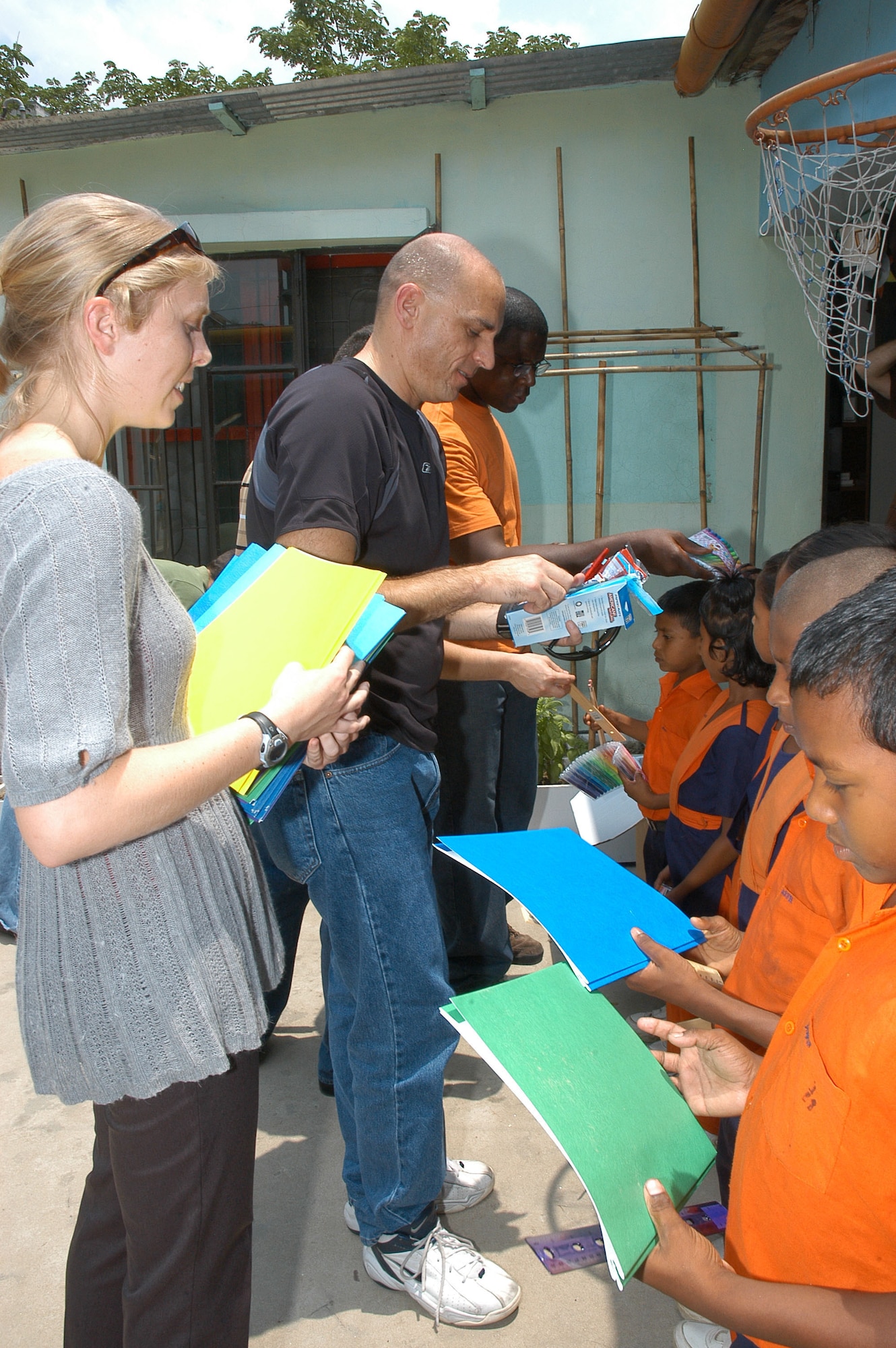 (From left) Captain Gretchen Holden, Senior Master Sgt. Jerry Wilkerson and Technical Sgt. Gideon Juko, all from the 353rd Special Operations Group, hand out school supplies to students in a school in Dhaka, Bangladesh.  Members of the 353rd SOG are deployed to Bangladesh to train with the Bangladesh Air Force. (U.S. Air Force photo/Master Sgt. Marilyn Holliday)                            