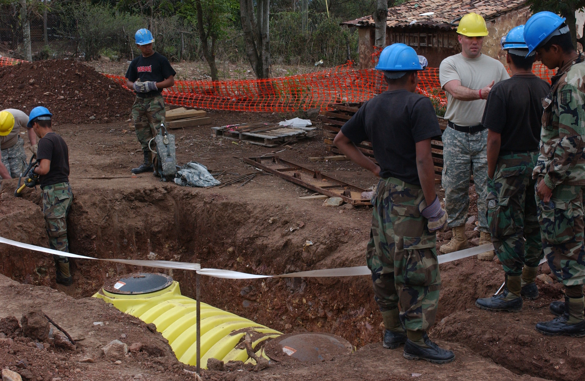 LAS MESAS, HON - Officer Candidate, Staff Sgt. Martin Berta, 322nd Engineer Company, Decorah, Iowa,  explains to Honduran army engineers how the newly laid septic tank functions here April 16. Photo by Staff Sgt. Danny McCormick, Beyond the Horizon public affairs.